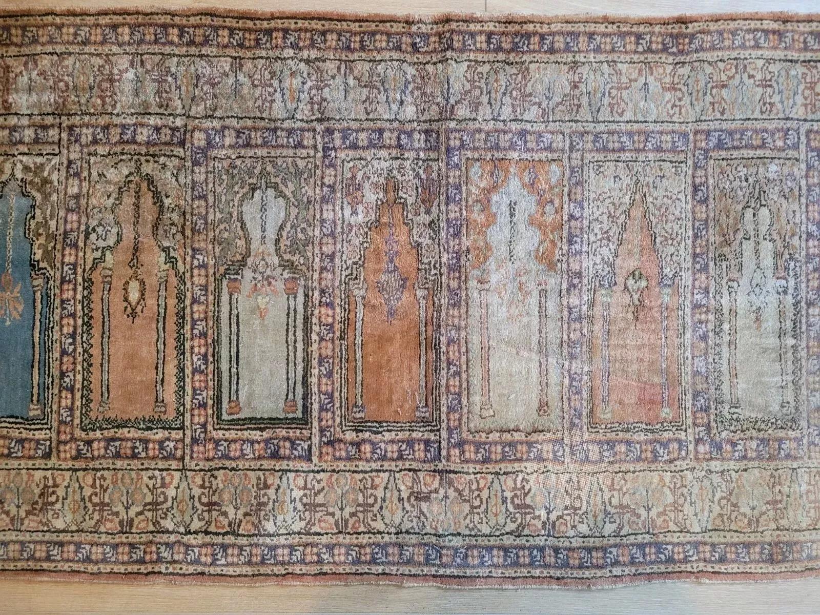 Esta preciosa alfombra de pasillo vintage, hecha a mano en la década de 1950 en Oriente Próximo, presenta la clásica tradición de tejido de Kayseri, conocida por su fina artesanía en seda y sus detallados diseños. La alfombra está tejida en lujosa