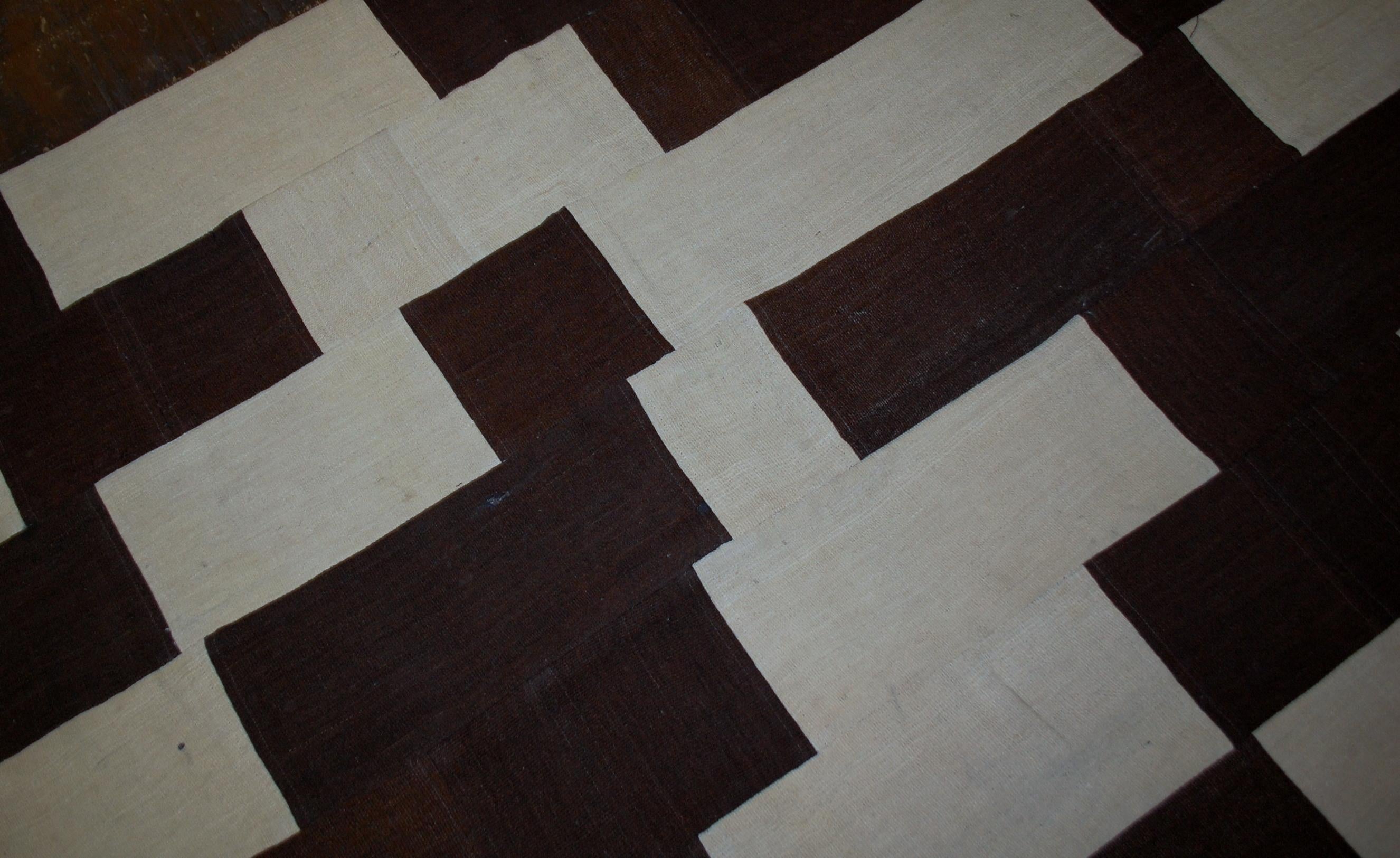 Handmade vintage Turkish Kilim patchwork in original condition. This Kilim made in white shade for the background and chocolate brown rectangles randomly placed on it. The Kilim is quite thick. Modern look will bring some style to the room. It is in