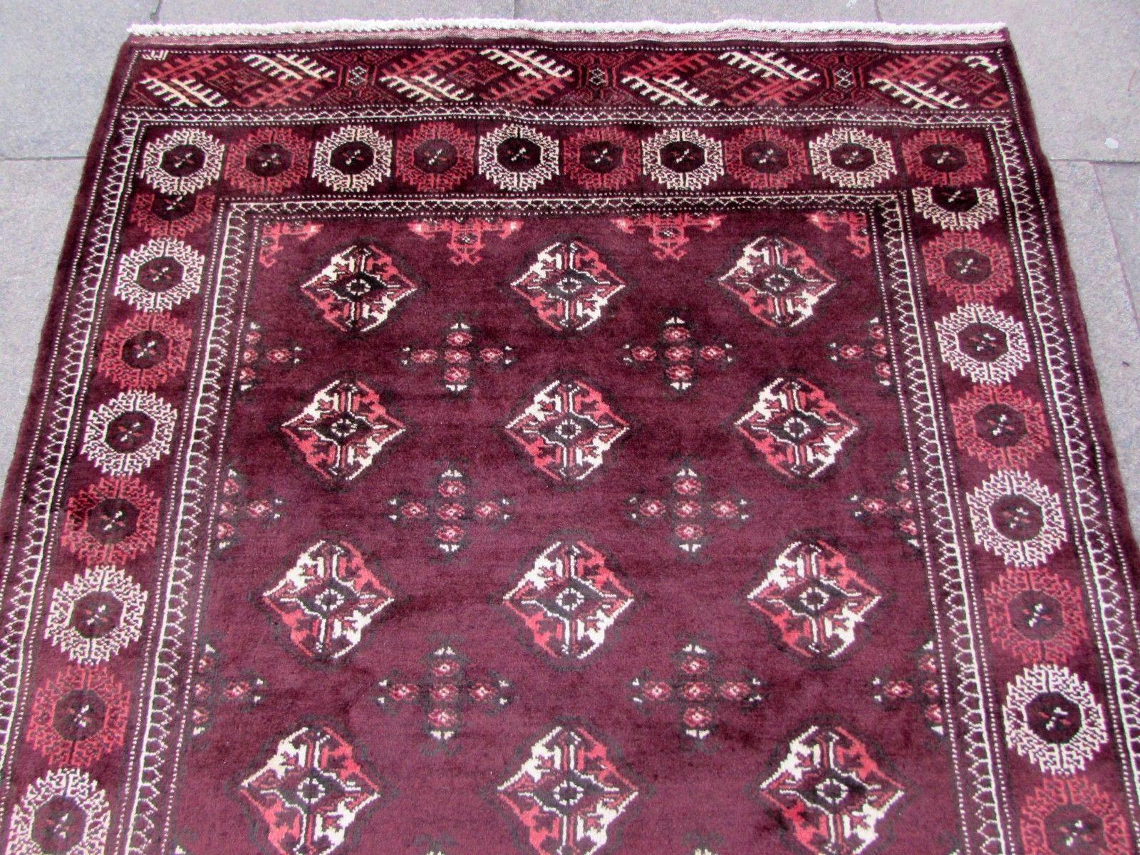 Handmade vintage traditional Turkmen Tekke rug in burgundy wool. The rug has been made in the end of the 20th century, it is in original good condition.

- Condition: original good,

- circa: 1970s,

- Size: 4.11' x 9.4' (147cm x 282cm),

-