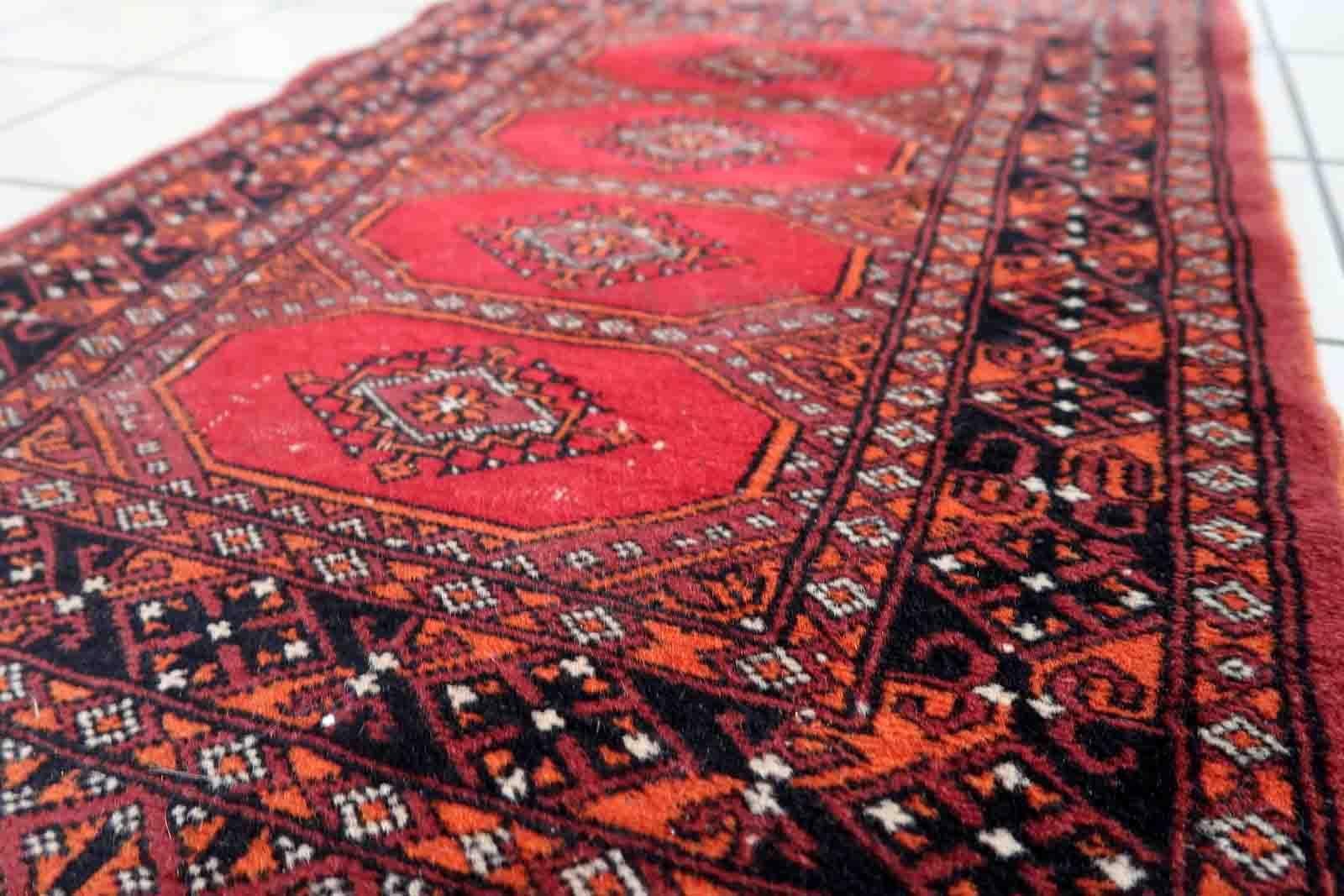 Tapis ouzbek Bukhara vintage fait à la main dans un style traditionnel. Le tapis date de la fin du 20e siècle et est fabriqué en laine. Le tapis est en bon état d'origine, un coin a été endommagé.

-état : original, un coin est endommagé,

-vers :