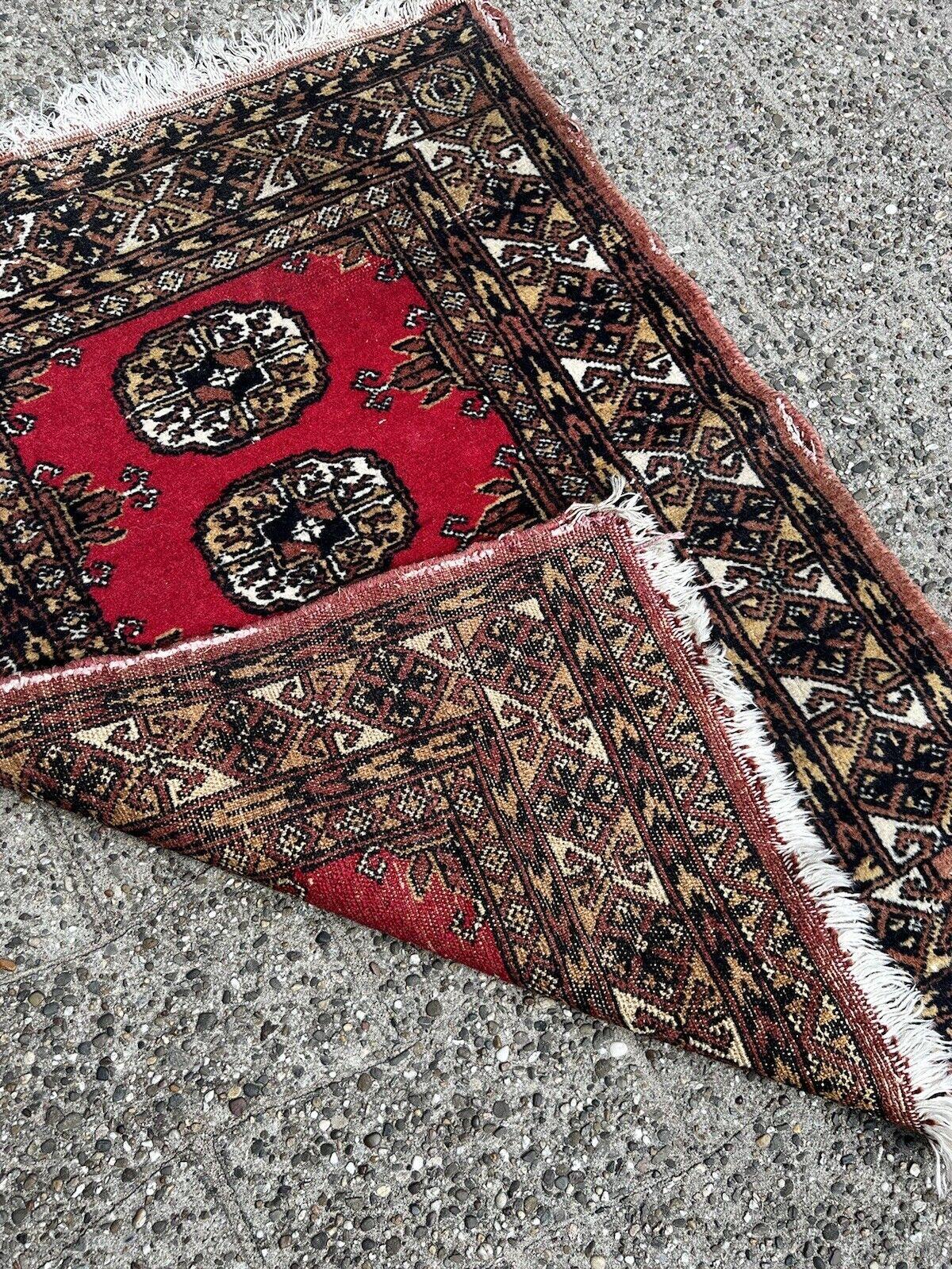 Step into the world of timeless elegance with our Handmade Vintage Uzbek Bukhara Rug. This authentic piece from the 1960s is a testament to the rich tradition of Uzbek craftsmanship, offering a glimpse into the past through its intricate design and