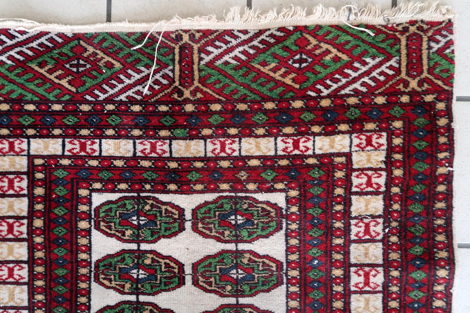 Dieser handgefertigte usbekische Buchara-Teppich aus den 1960er Jahren ist ein beeindruckendes Beispiel für traditionelle Handwerkskunst. Mit einer Breite von 77 cm (2,5 Fuß) und einer Länge von 128 cm (4,2 Fuß) ist dieser schöne Wollteppich in