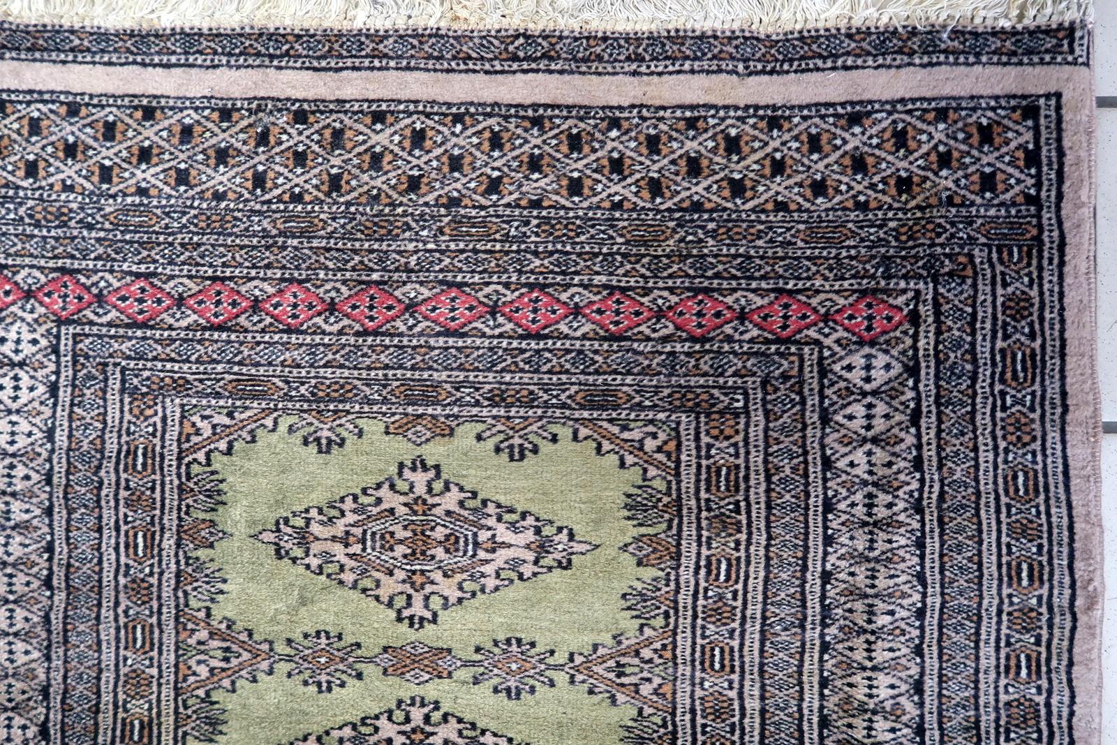 Verschönern Sie Ihren Raum mit dem zeitlosen Charme dieses handgefertigten usbekischen Vintage-Teppichs aus Buchara. Dieses exquisite Stück aus den 1950er Jahren misst 2,6' x 4' (82cm x 122cm) und verströmt das reiche Erbe usbekischer