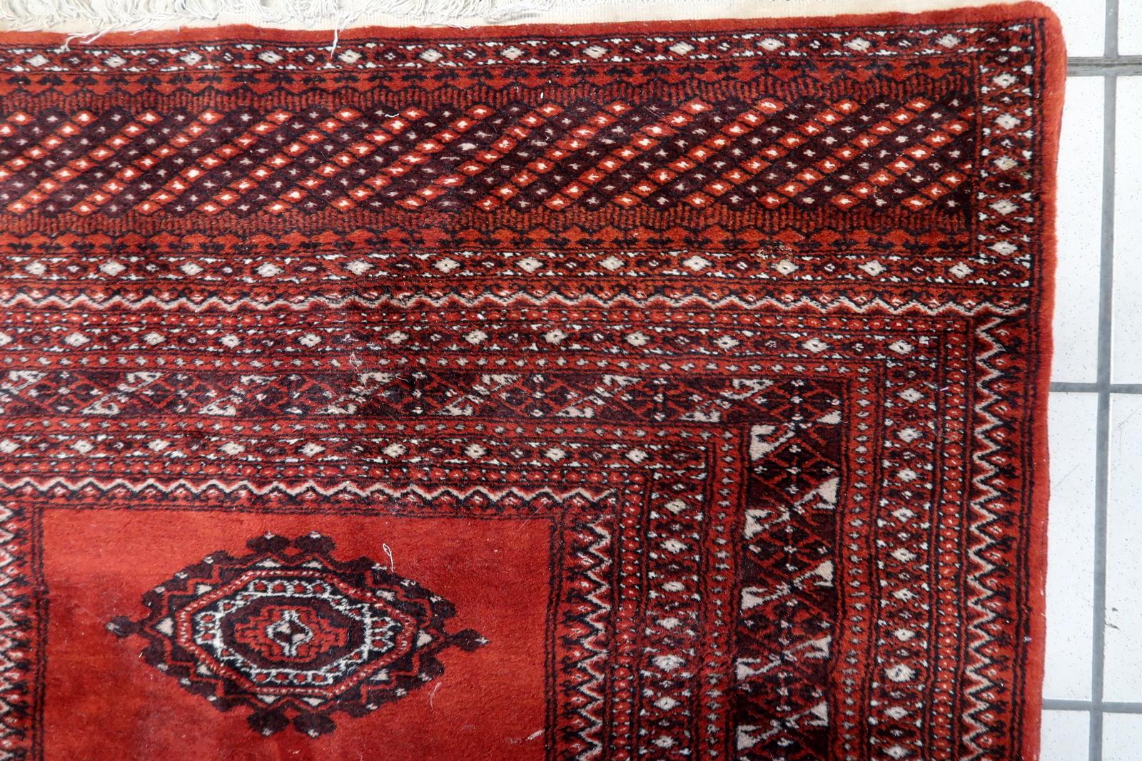 Elevate your space with the timeless elegance of this Handmade Vintage Uzbek Bukhara Rug, a stunning piece from the 1950s. Measuring 3' x 5.1' (94cm x 156cm), this exquisite rug boasts a traditional design that will add character and charm to any