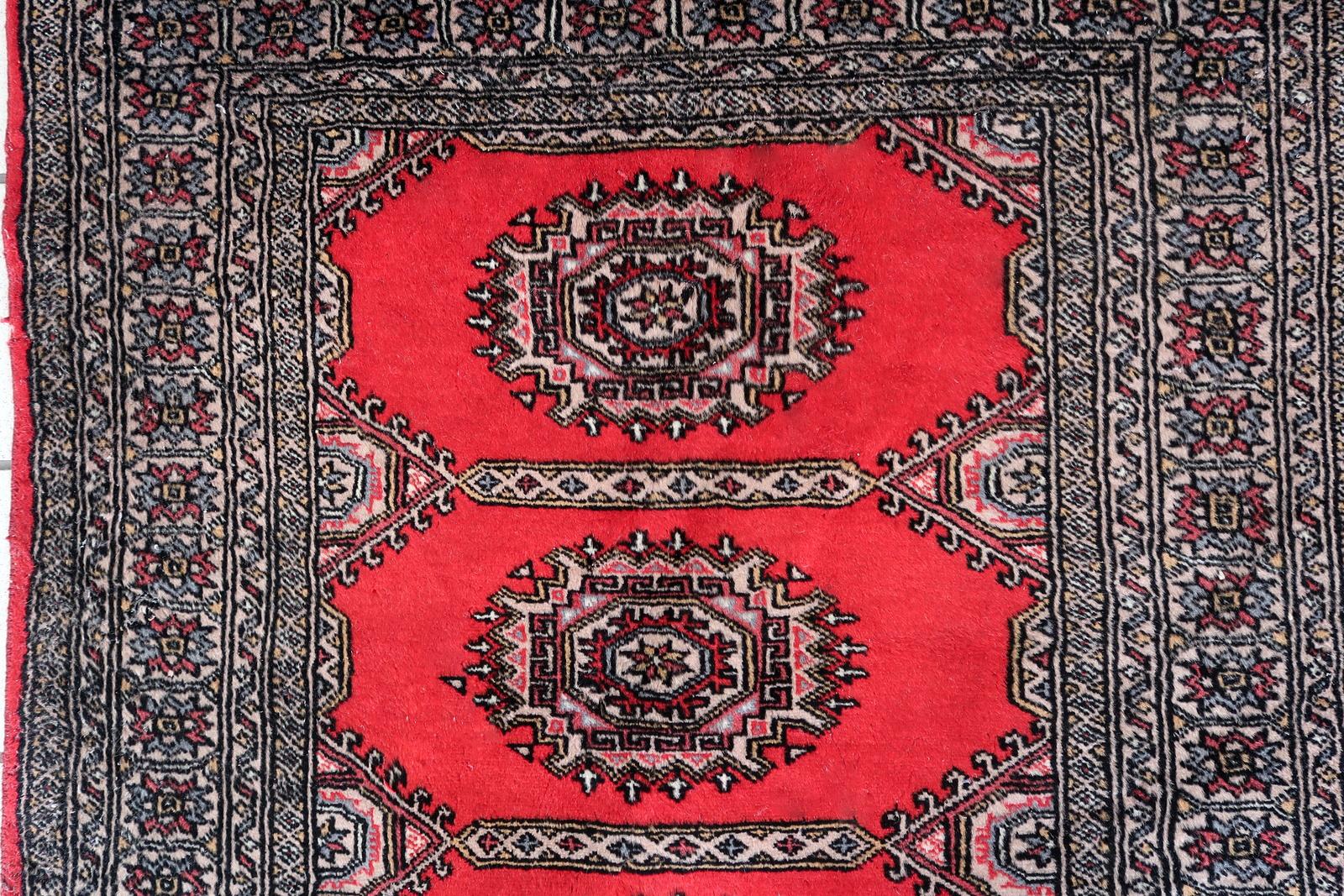Elevate your living space with our captivating Handmade Vintage Uzbek Bukhara Rug. Dating back to the 1960s, this exquisite piece carries the rich history and timeless allure of Uzbekistan. Measuring 3' x 6.1' (92cm x 186cm), it's the perfect