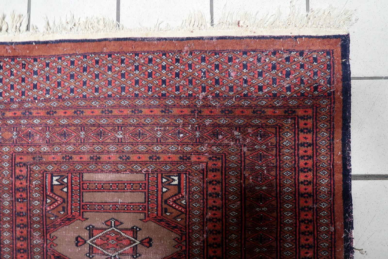 Alfombra antigua de lana anudada a mano de Uzbekistán, pelo bajo, 3,1' x 5,1
Alfombra auténtica de Bukhara uzbeka de mediados de siglo, circa años 50
Experimenta el rico patrimonio textil de Asia Central con esta llamativa alfombra vintage de