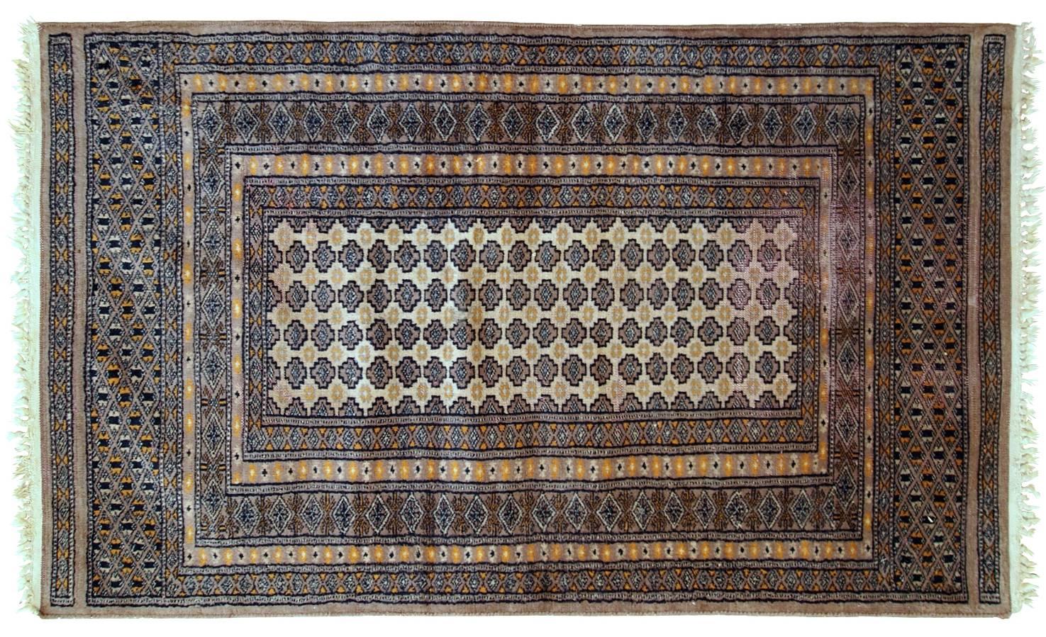 Handmade vintage Uzbek Bukhara rug in original condition. All-over design with repeating pattern in the centre on the beige field. Large detailed border. The rug has some low pile on one side.
 