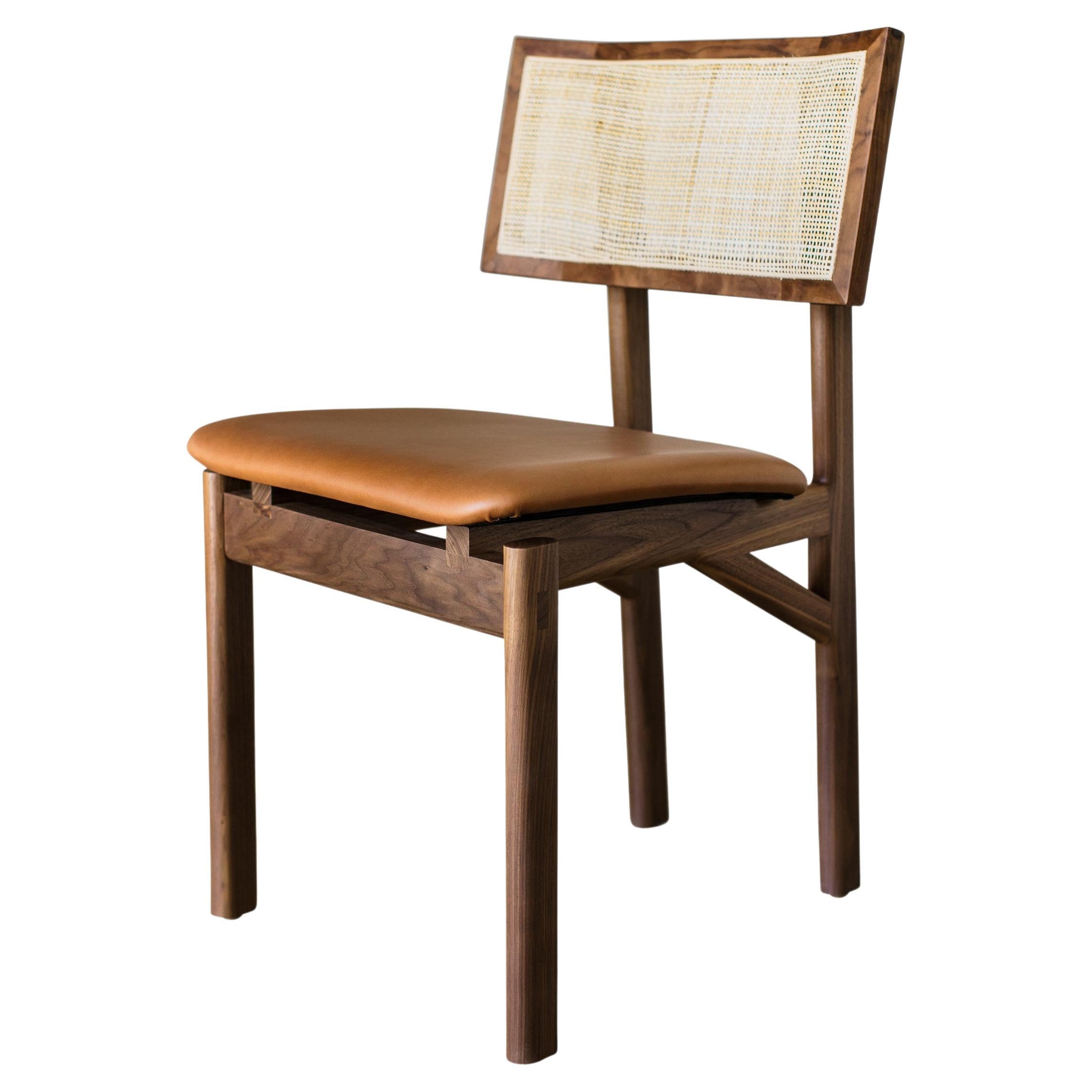 Solid wood constructed dining chair available in any American domestic hardwoods specifically walnut, oak, ebonized oak, or ash. Featuring hand-shaped legs, a custom upholstered seat available in camel leather, olive leather, black leather, vegtan