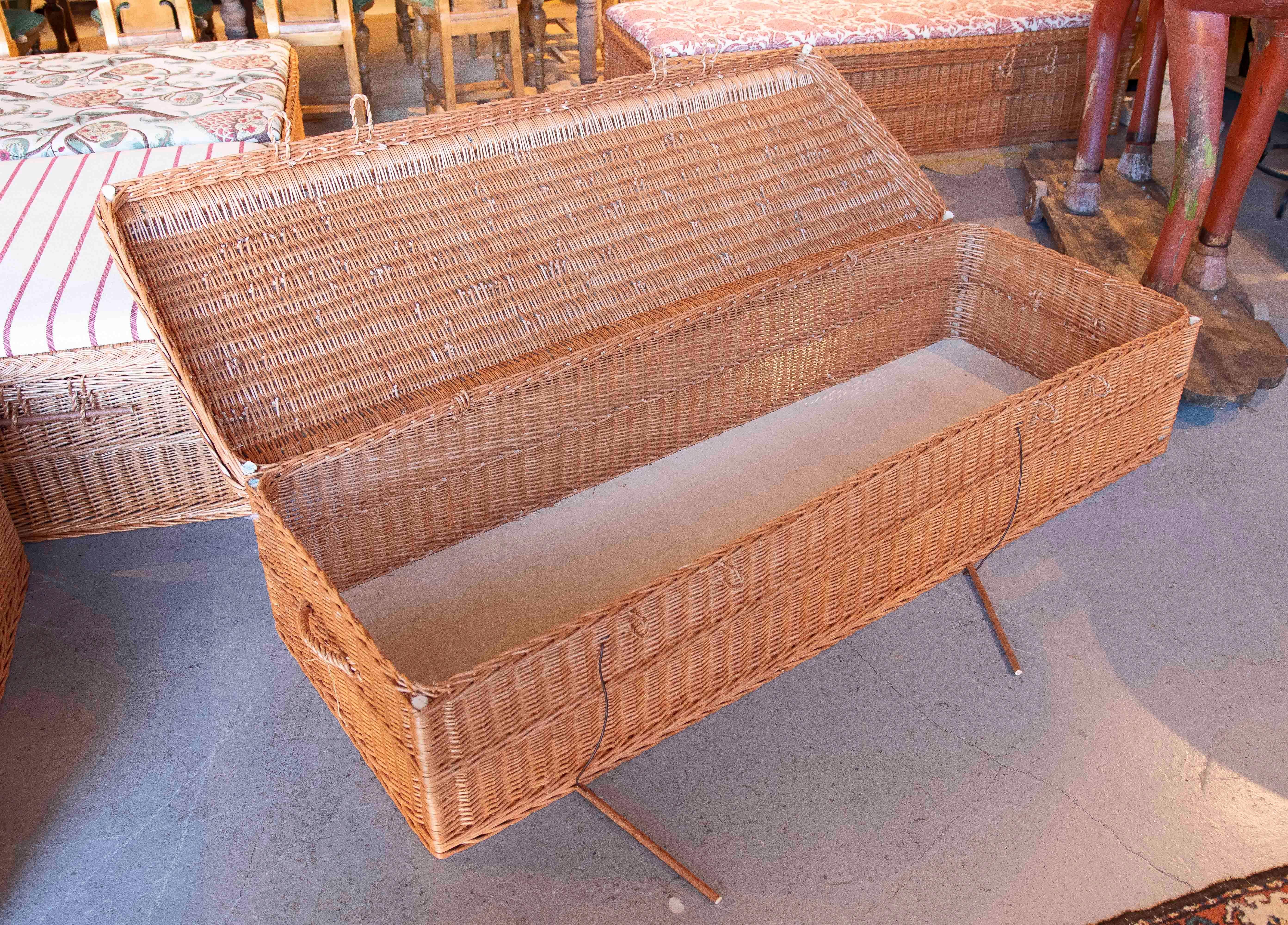 Table basse élégante en osier fait main, conçue avec un plateau paddé et revêtue d'un tissu floral sophistiqué dans les tons rougeâtres et beiges. Cette pièce allie fonctionnalité et style classique. Elle est idéale comme siège et pour maintenir