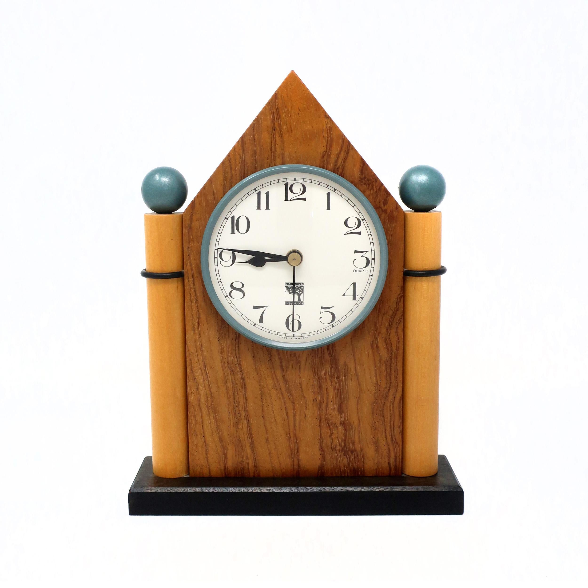 A gorgeously handcrafted wood mantel or desk clock made by in 1990 by Kasnak Designs of Indianapolis, Indiana. A perfect mix of 1980's Memphis Milano-inspired design and Mission/Art & Crafts expert woodworking. Dark stained wood base with black