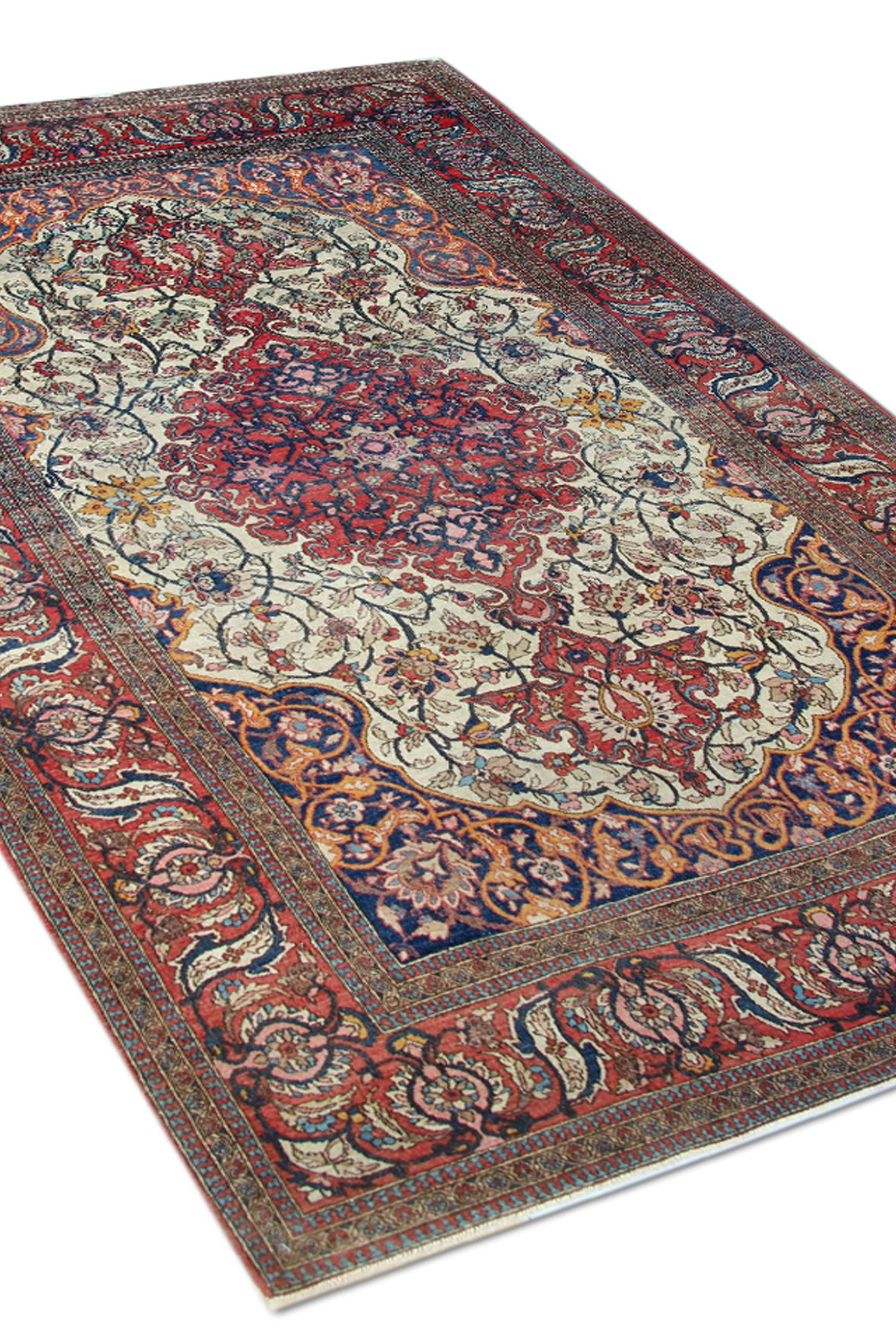 An antique central medallion rug is a fine example of an Antique Rug woven in the 1900s. Handwoven with intricate details in orange blue and red accent colours. The design features an ivory central field with a highly detailed central medallion of