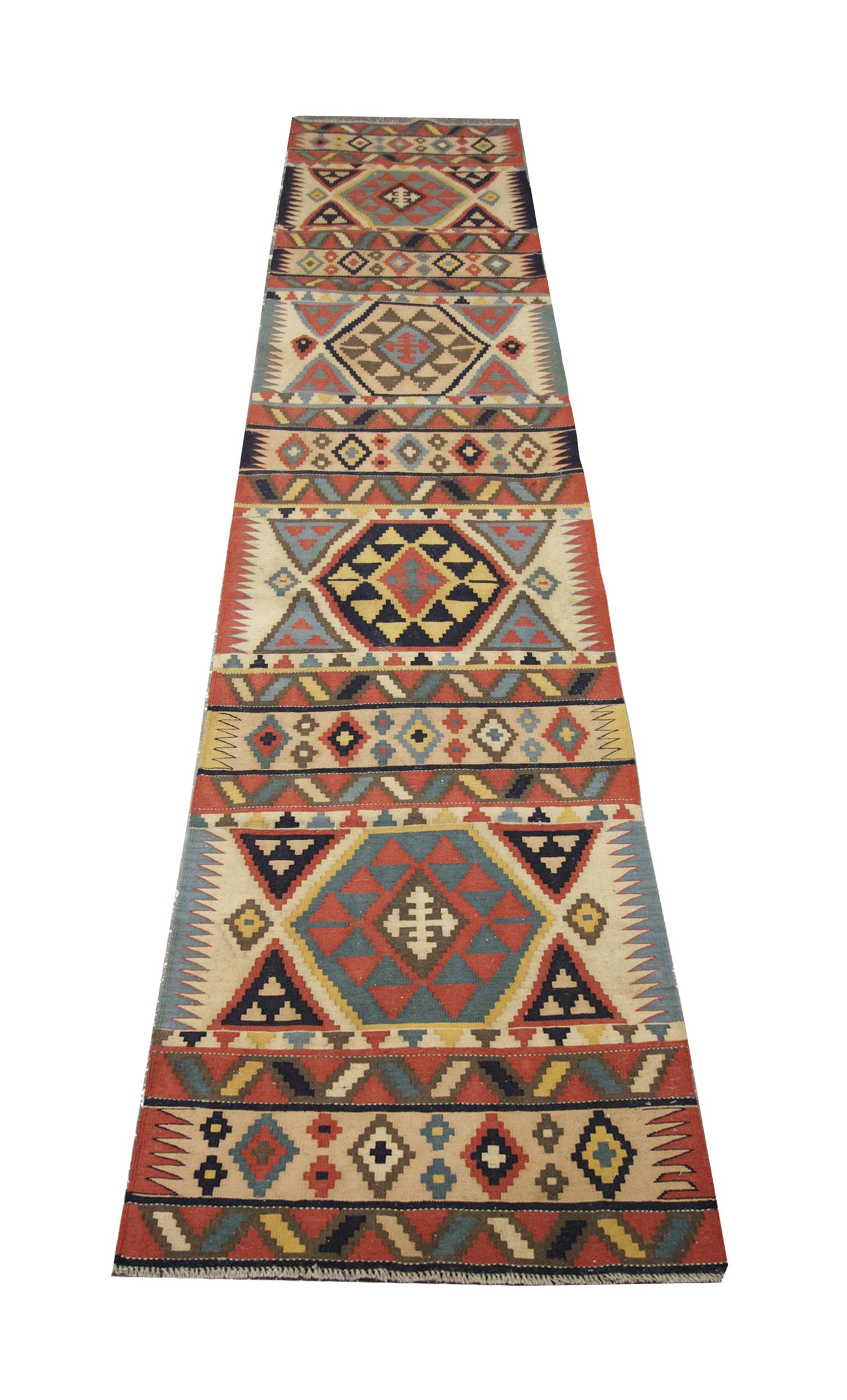 Le chemin de table en laine beige Kilim fait à la main est une pièce magnifiquement fabriquée qui allie le charme rustique au design tribal traditionnel. Doté d'un motif géométrique en beige doux avec des accents multicolores, ce chemin de table