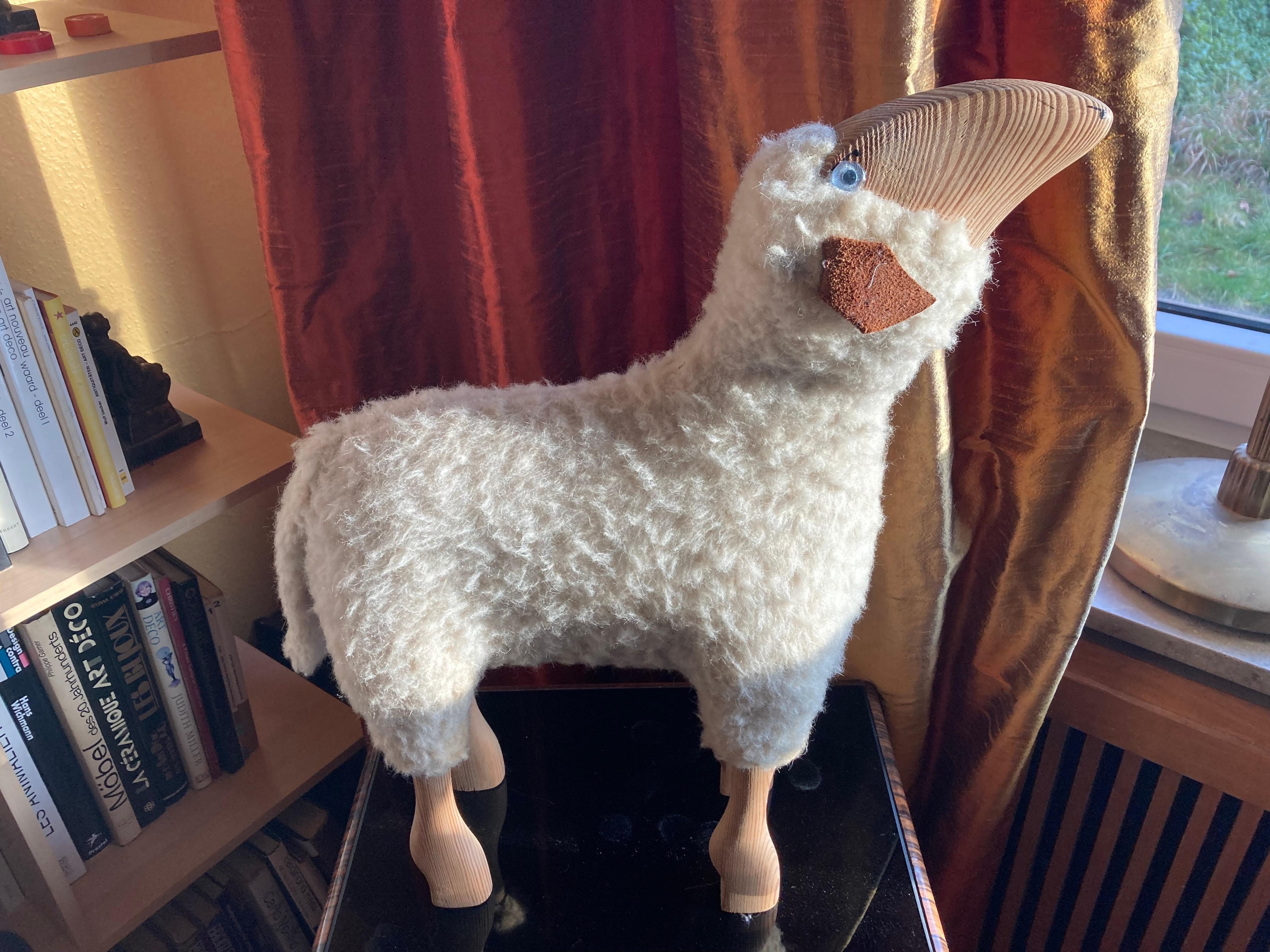 Rare wool lamb by Hanns-Peter Krafft. Germany 1970s. The lamb was handmade from original white wool, leather and solid high-quality beech wood. The entire production took place in Germany in the 1970s.
The sheeps originally served as a stool for
