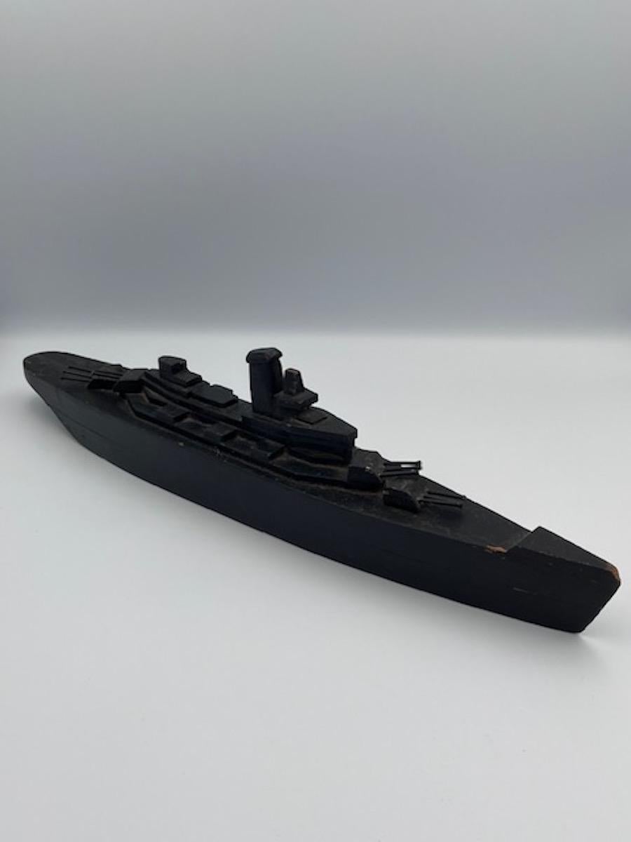 Este acorazado de arte popular hecho a mano a principios de la década de 1940 es un notable ejemplo de artesanía bélica, que refleja tanto el espíritu patriótico como el ingenio de la época. Fabricado enteramente en madera, presenta una combinación