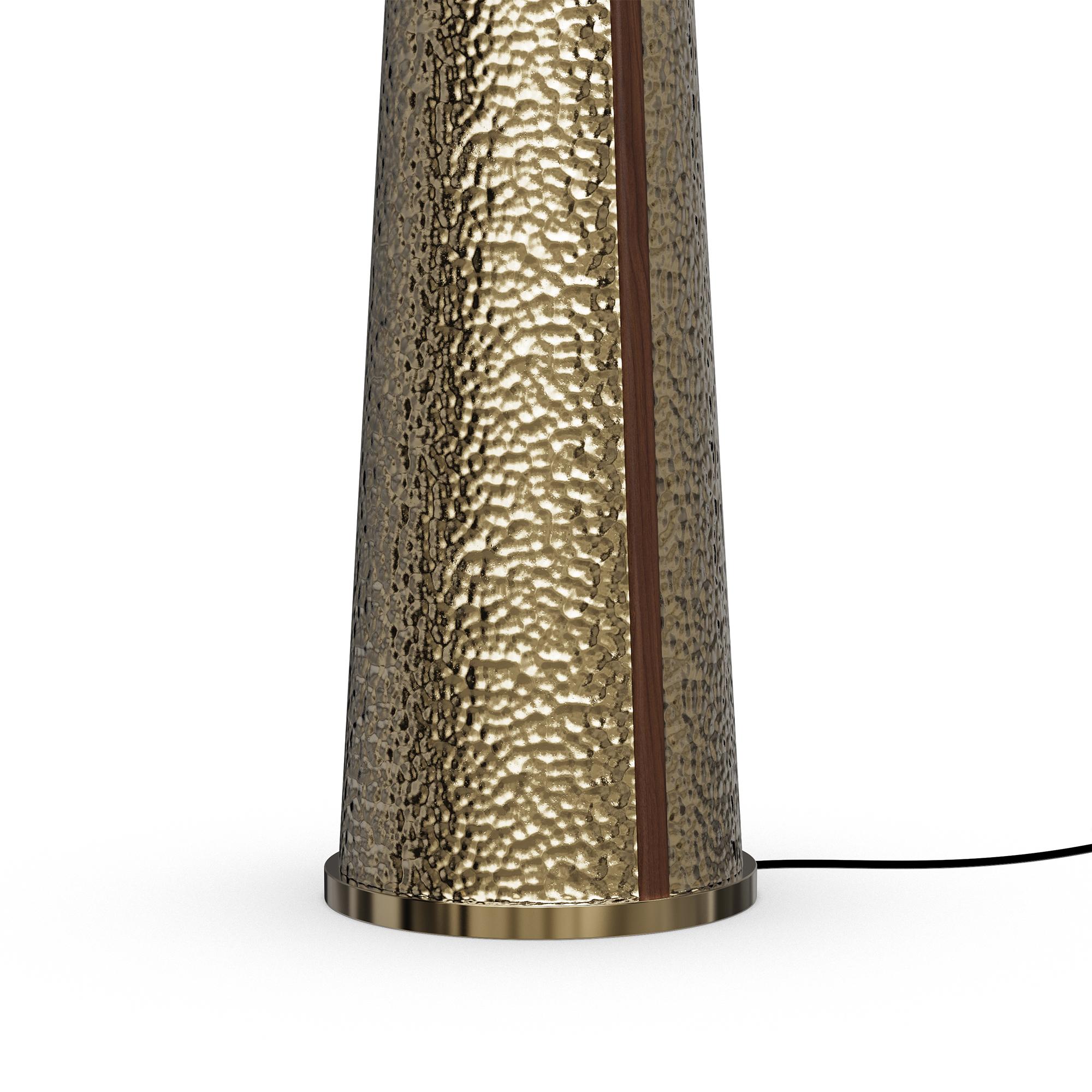 Le lampadaire Yves est une déclaration audacieuse de savoir-faire et de sophistication, conçue pour apporter chaleur et luxe à tout espace. Sa base conique effilée, fabriquée en laiton martelé, présente une surface riche et texturée qui capte et