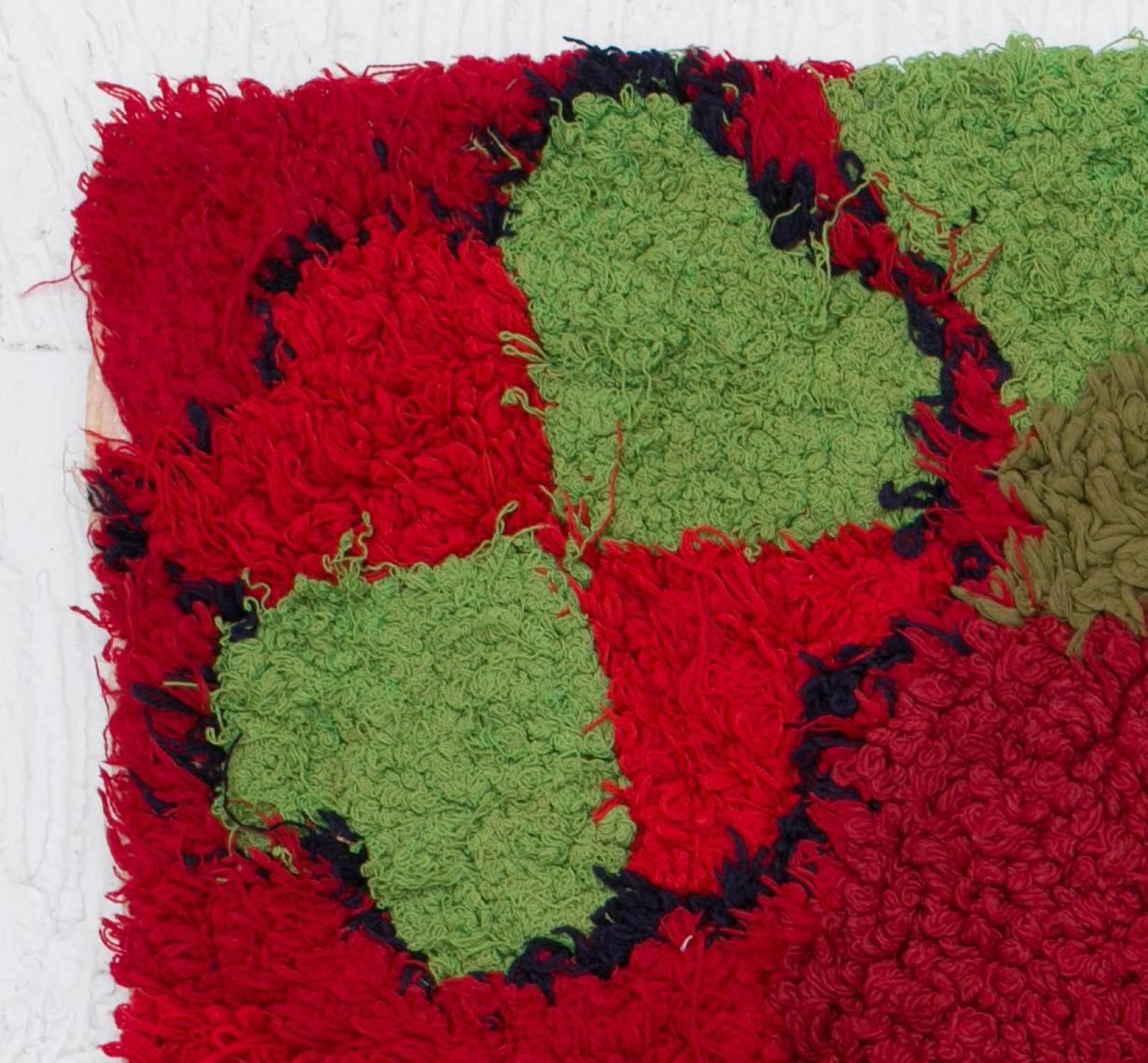 Berber red tapestry realized by the women of the Atlas. This work on a red background symbolizes passion but also the birth of love with its green and blue hearts. Homogeneous and simple, this piece is the perfect representation of the secret
