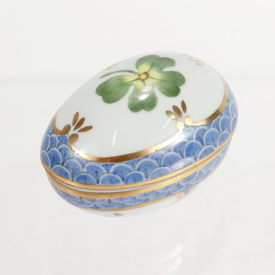A fine diminutive porcelain dresser or vanity box.

By Limoges for Asprey.

In the size and shape of an egg. Decorated with handpainted green plants, blue devices, and extensive gilt accents.

Marked to the base Limoges / France / Handpainted