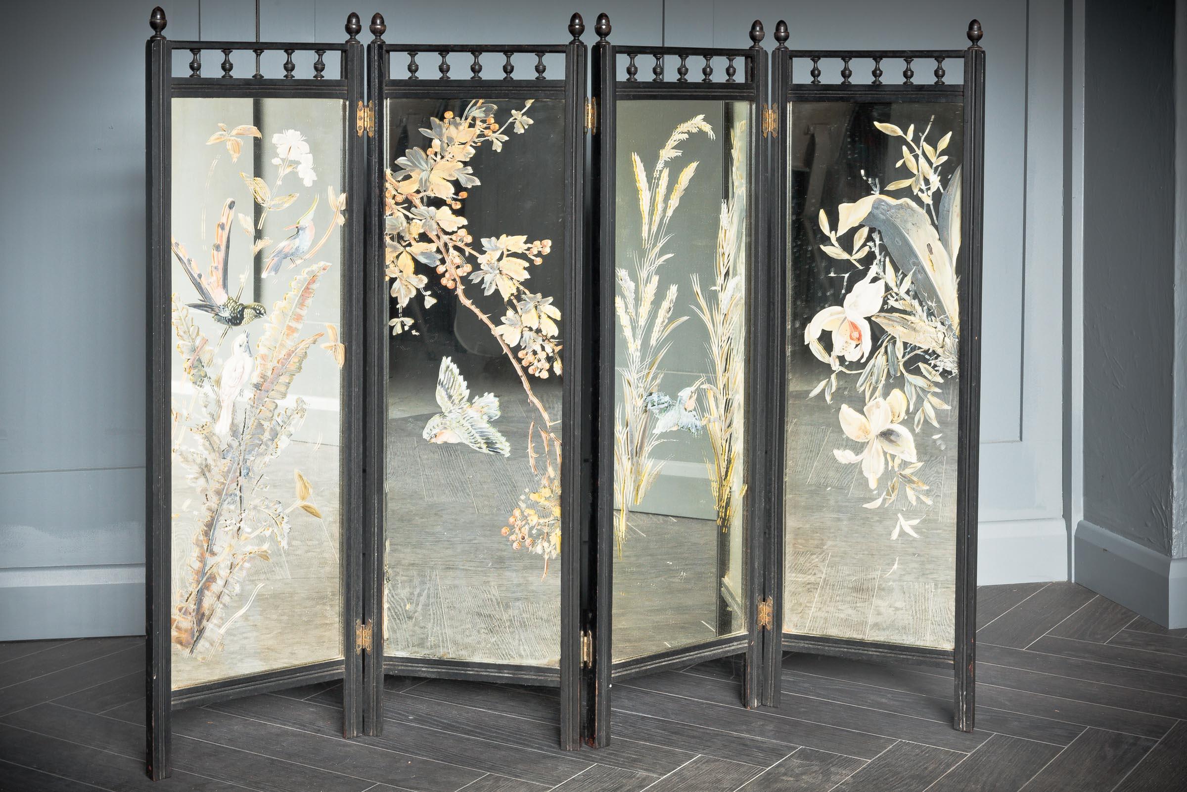 Cet étonnant écran miroir en bois en quatre parties présente un motif floral visuellement saisissant accompagné d'oiseaux en vol plané peints à la main sur la partie miroir de l'écran. Le design est typique de l'Angleterre victorienne. Le bois a été