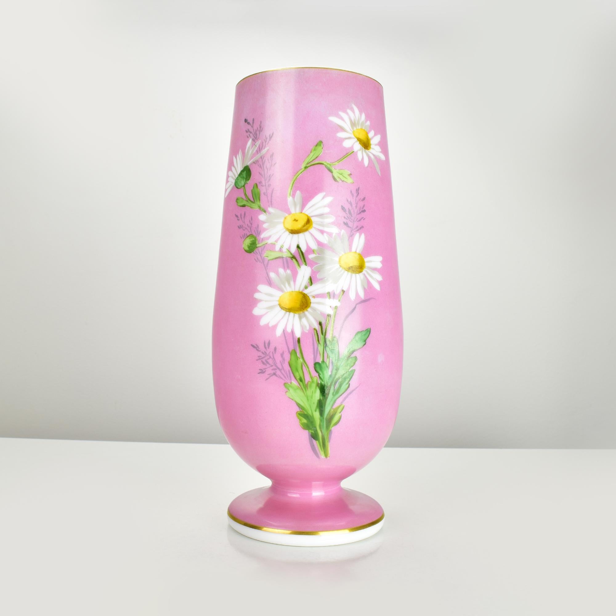 Diese elegante Vase aus rosafarbenem Opalglas aus dem 19. Jahrhundert, die Baccarat zugeschrieben wird, ist ein wahres Beispiel für raffinierte Handwerkskunst. Die Vase zeigt ein bezauberndes handgemaltes Blumendesign mit weißen Gänseblümchen und