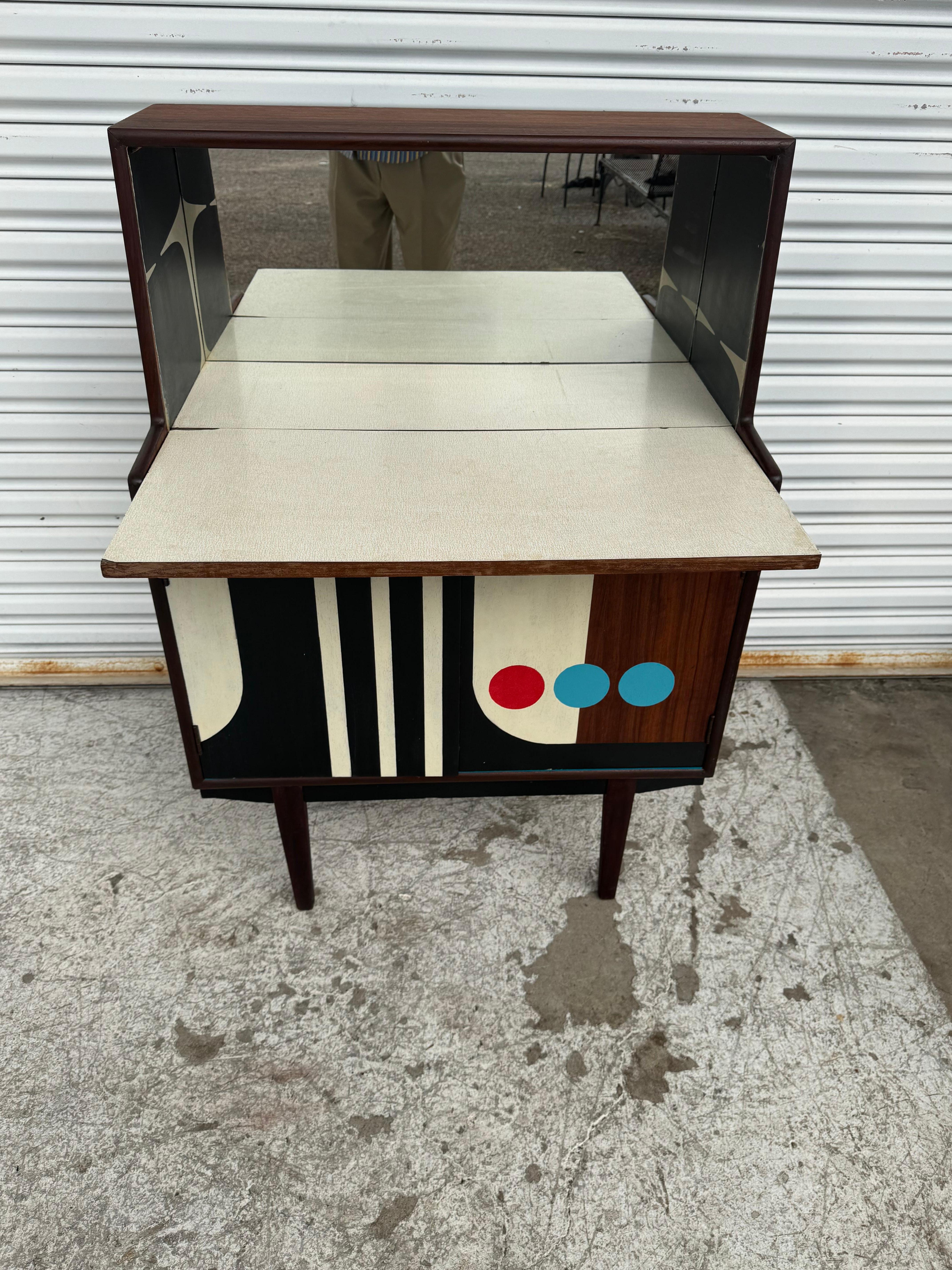 Este escritorio fue fabricado por Turnidge de Londres.
Es de madera de palisandro y tiene dos puertas inferiores que dan acceso a mucho espacio de almacenamiento. La barra tiene una cara frontal abatible para guardar muchas libaciones.
La parte