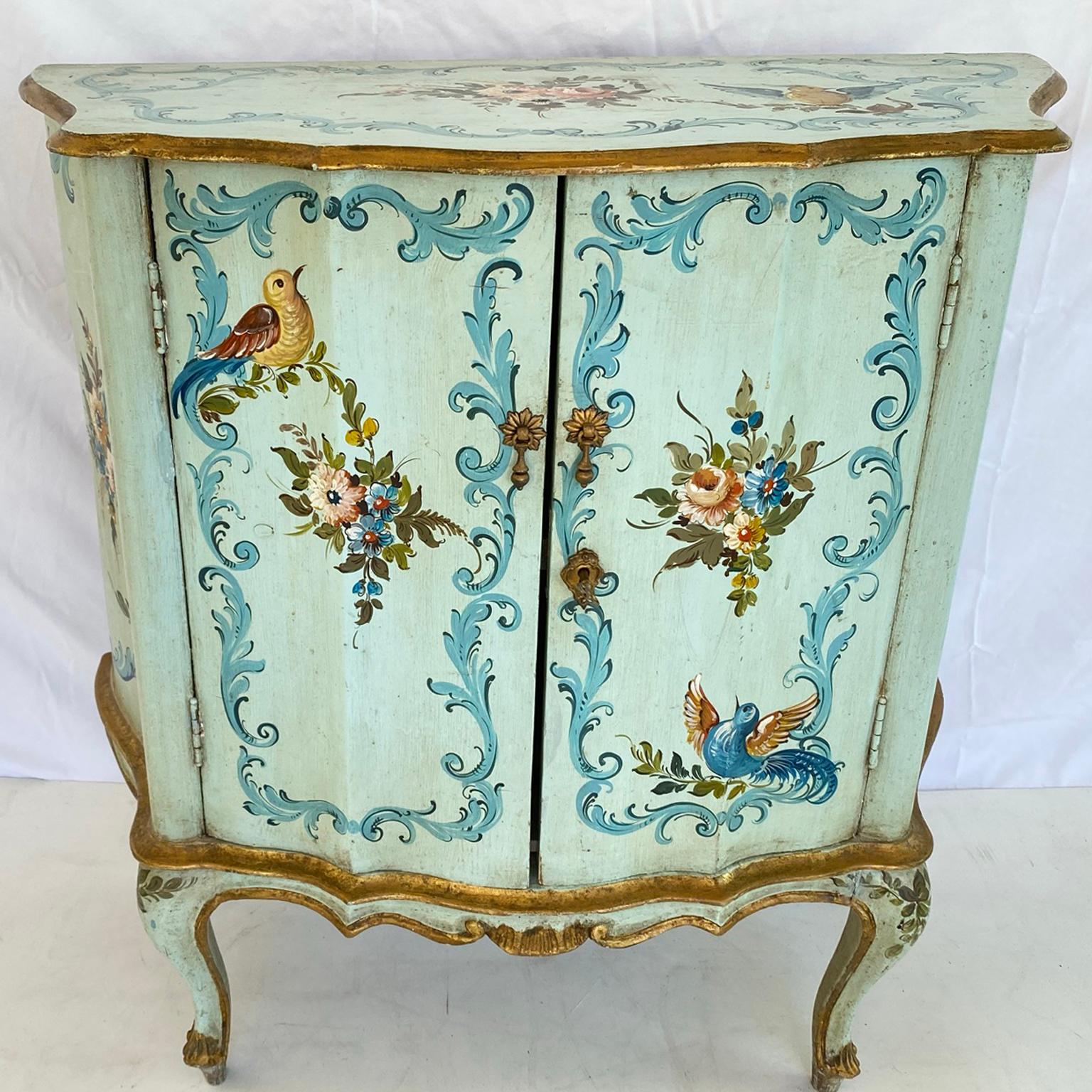 Cabinet, with its top, front, and sides handpainted with birds, florals, and scrolling decoration; its serpentine top on conforming base of double cabinet doors, shaped apron centered with combing, raised on cabriole legs. 

Stock ID: D1137.