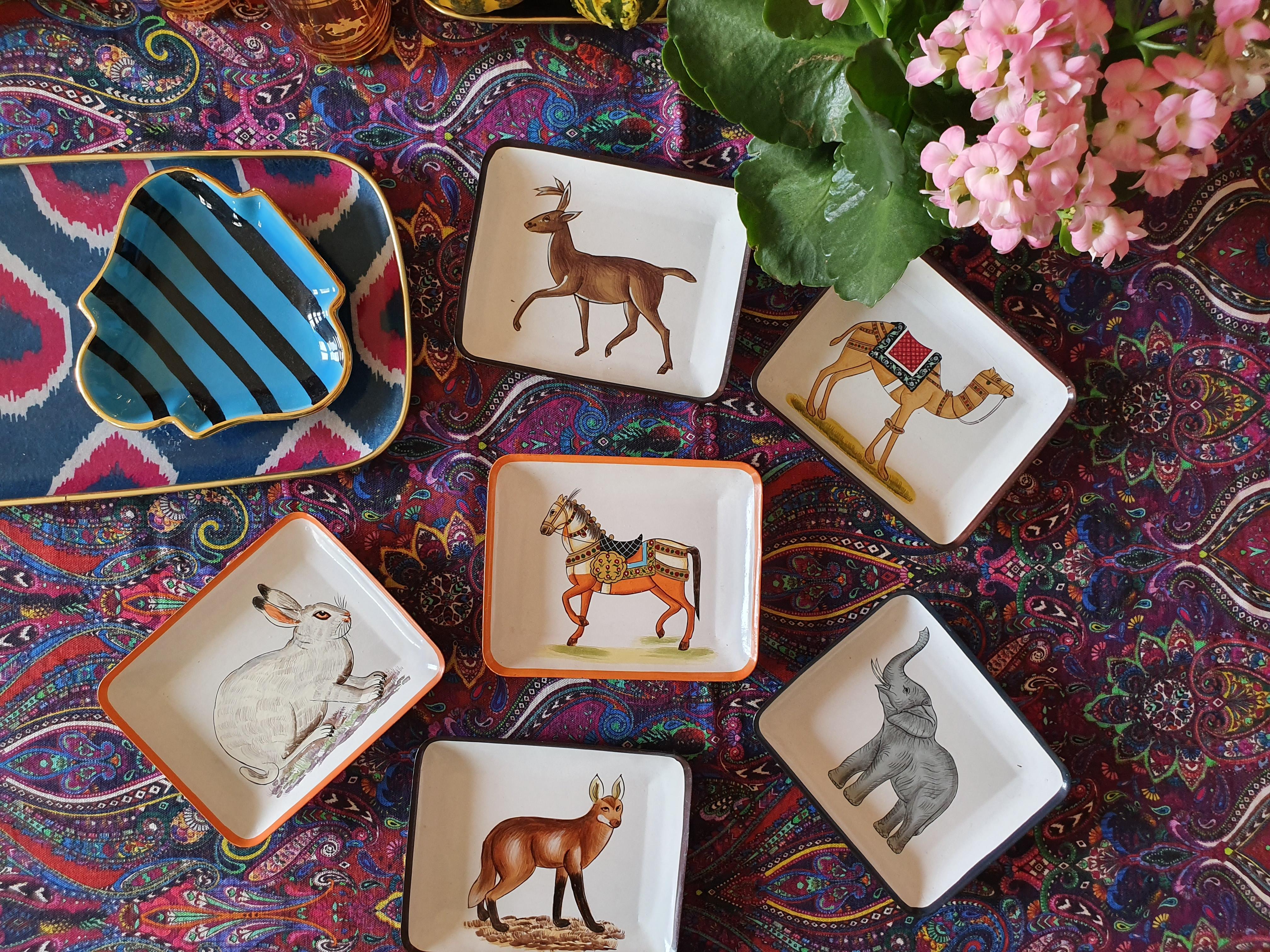 Añade un toque de elegancia exótica a tu hogar con este juego de 3 vide poches de hierro pintados a mano, que muestran la encantadora colección de animales otomanos. Perfectas para organizar objetos pequeños o como complementos decorativos, estas
