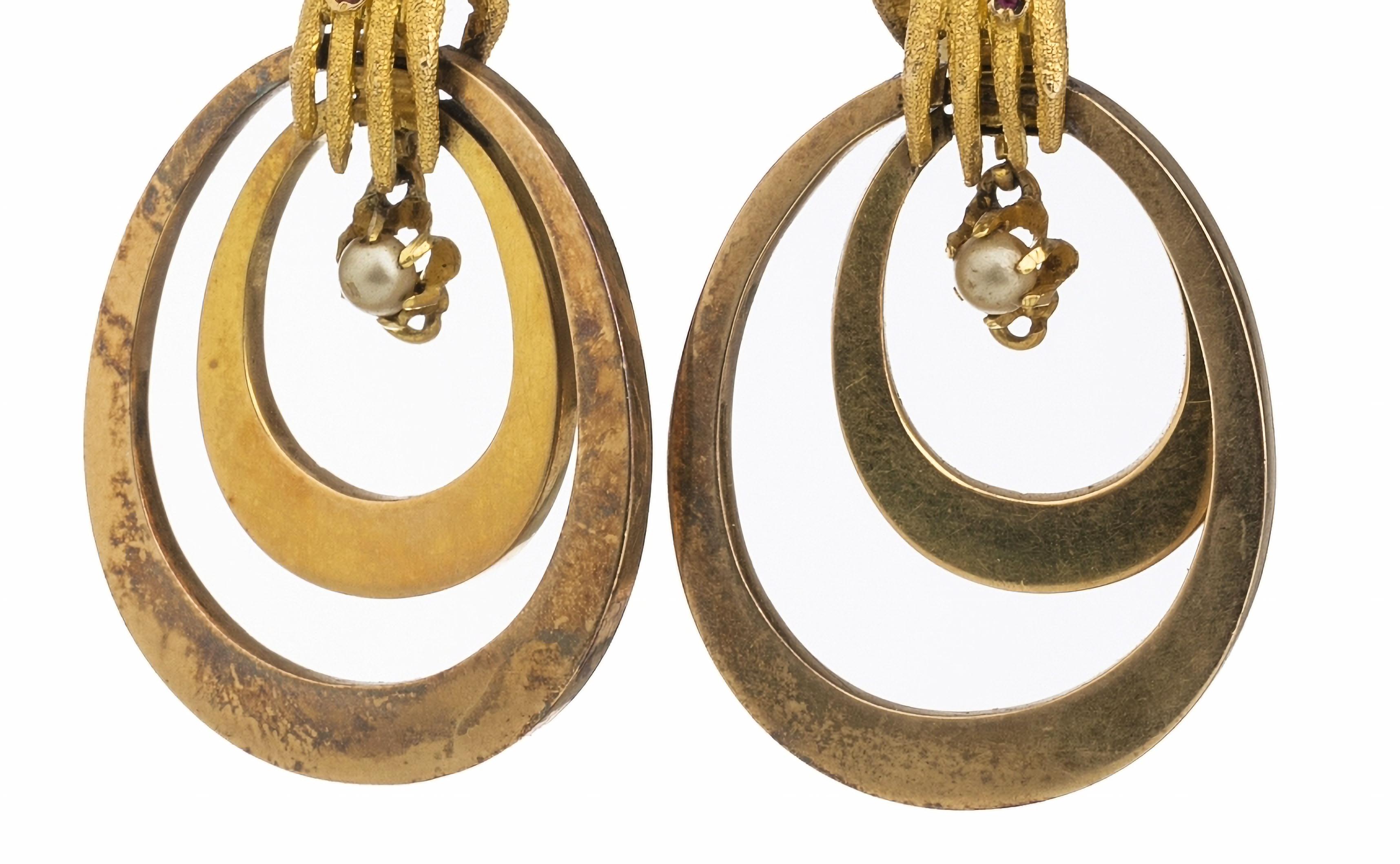 Ohrringe 'Hands' aus Gold
Viktorianisches 19. Jahrhundert, in 18-karätigem Gold, mit gravierter Dekoration und mit Rubinen, Cabochon-Schliff und Mikroperlen besetzt, mit französischem Exportstempel 