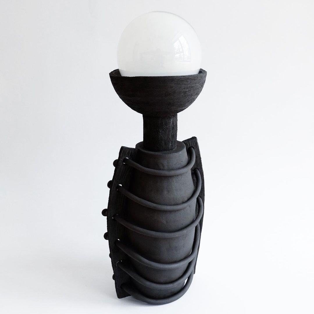 Handsculped Ike lamp by Ia Kutateladze
Dimensions: W x H cm
Materials: Raw Black Clay

IAAI / Ia Kutateladze is a Georgian multidisciplinary designer based in Berlin. The production is done by her in the studio, where different
mediums of