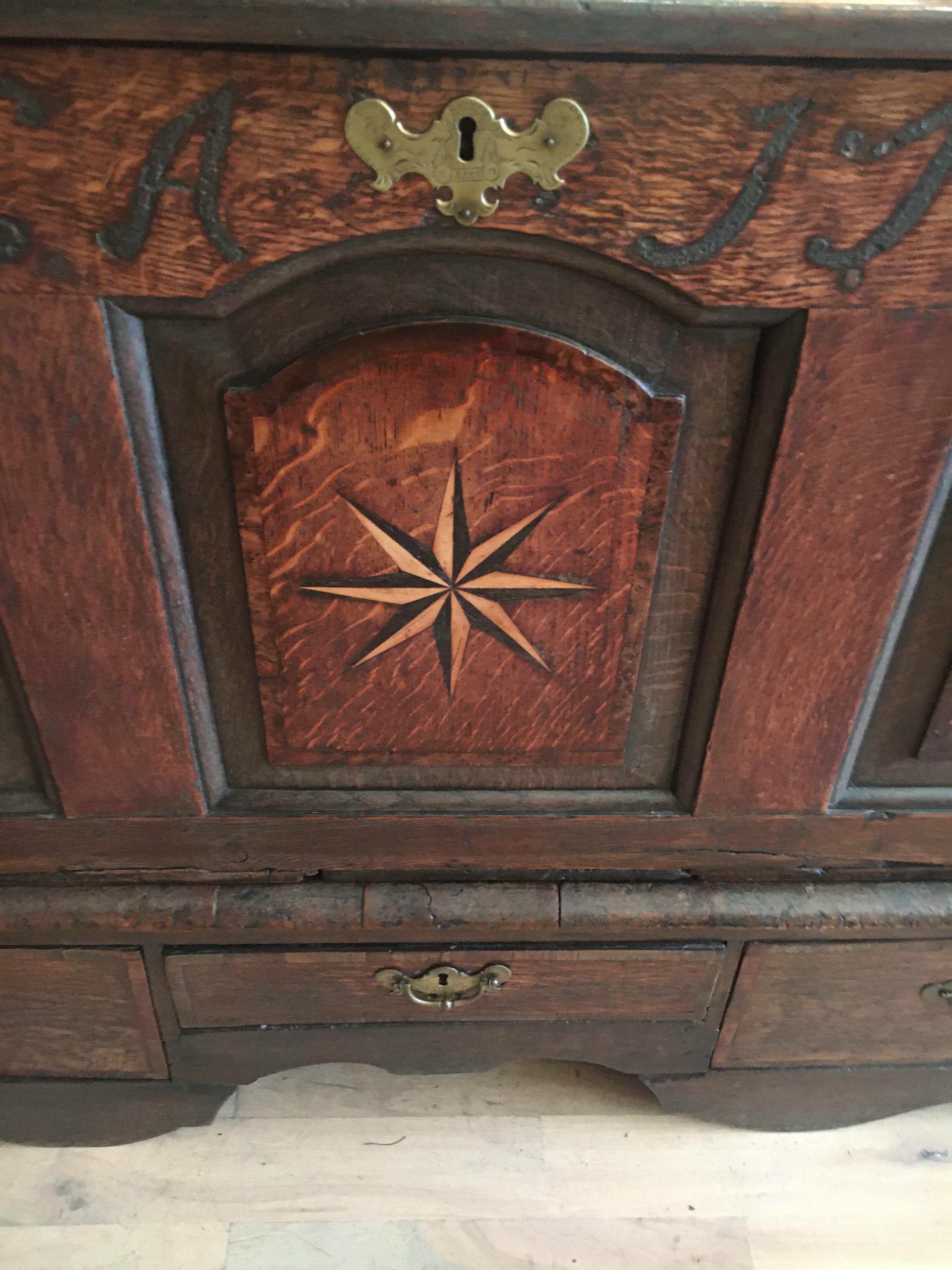 Handsome 18th century English oak chest with star inlay, dated 1730. Great patina and color, lift top over three drawers. This is a spectacular piece with great inlay and detail. It has been gone over so is ready for installation.