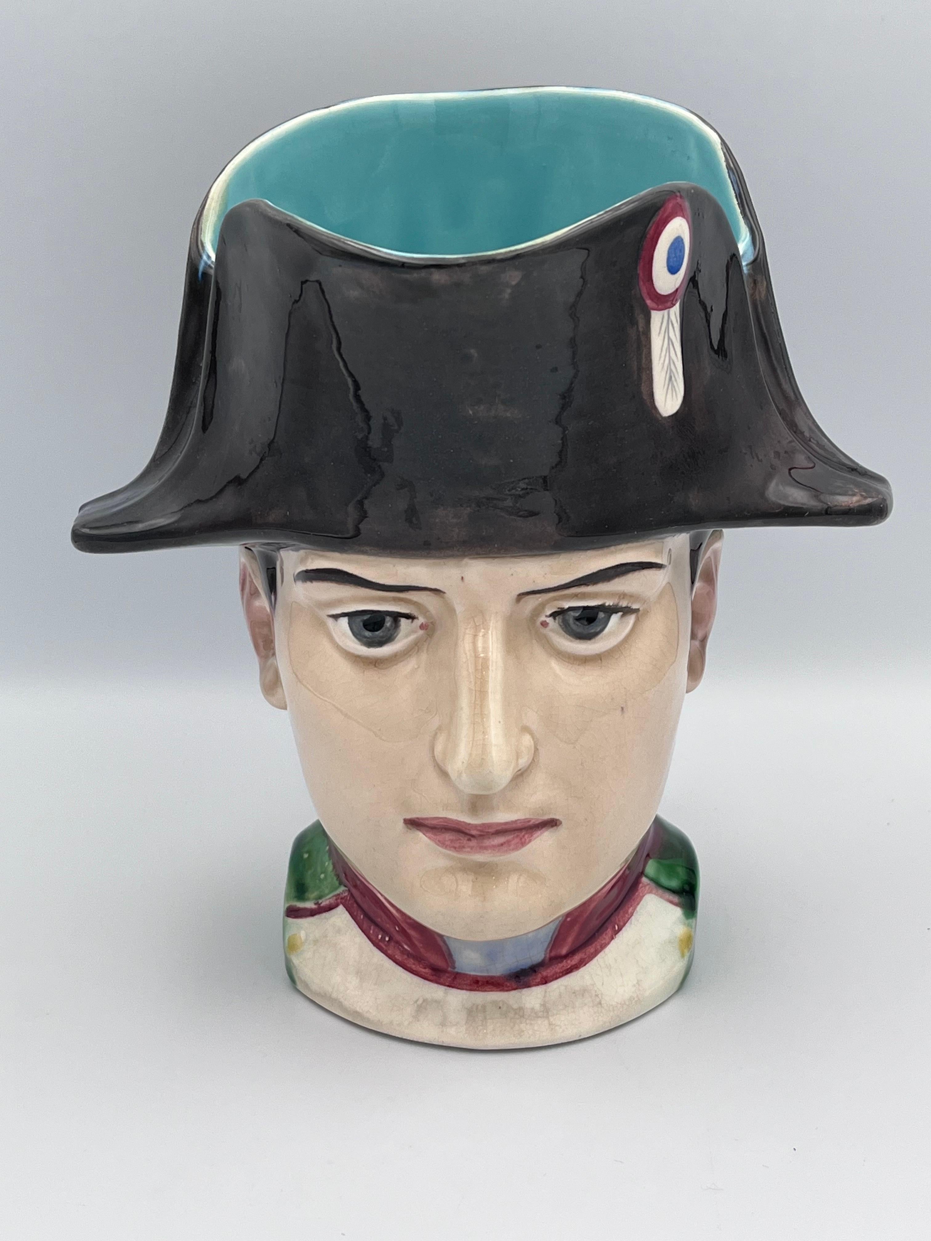Ein seltener und außergewöhnlich schöner Majolika-Becher aus den 1920er Jahren von Sarreguemines, Frankreich, der einen jugendlichen Napoleon Bonaparte in leuchtenden Farben und exquisiten Details darstellt. Diese wunderschön modellierte Tasse zeigt