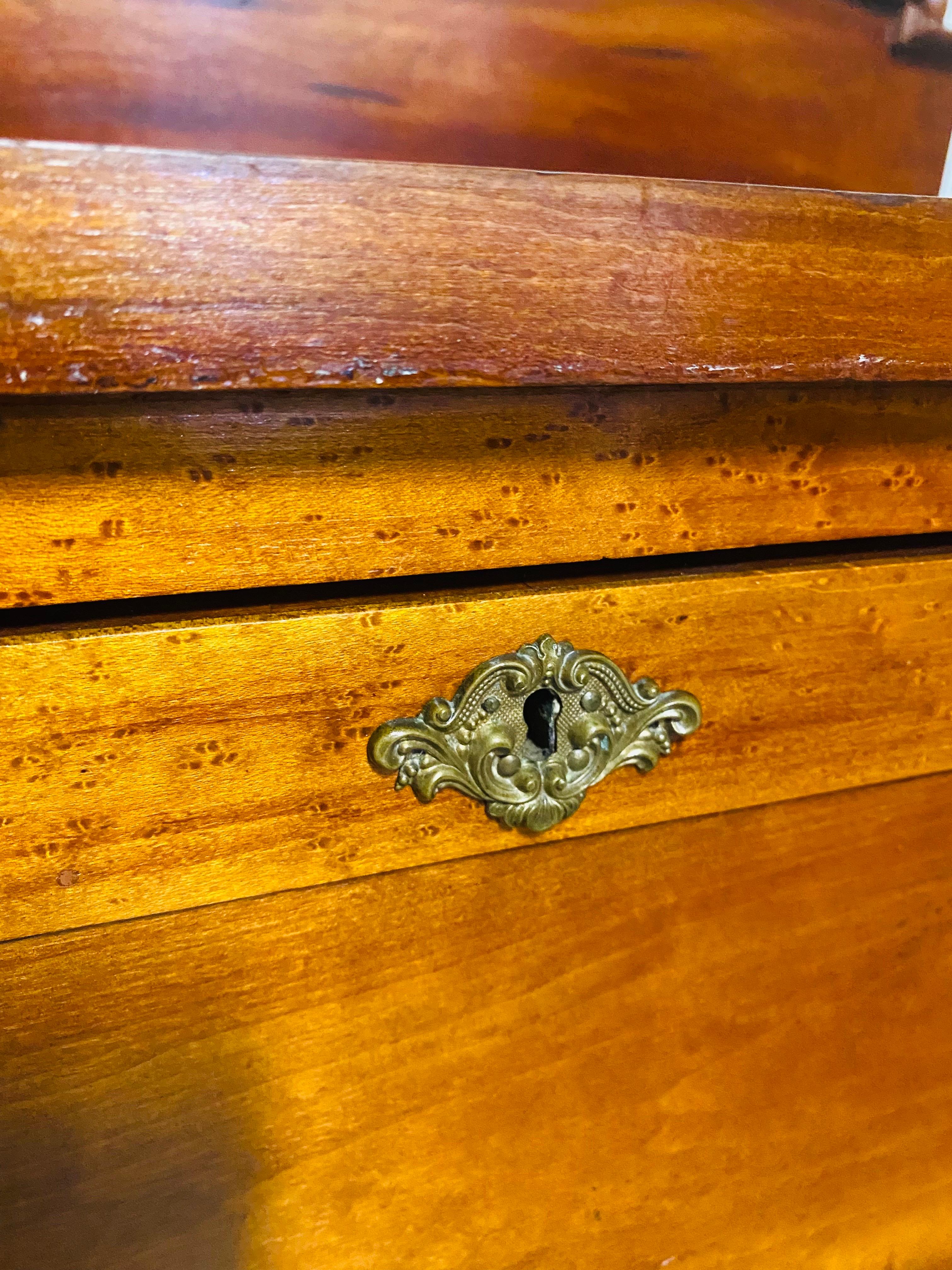 This is a handsome late 19th century handcrafted American Empire chest of drawers. This chest of drawers features its original solid brass ornately decorated pulls and keyhole covers. The chest of drawers was handcrafted in Pennsylvania circa 1870