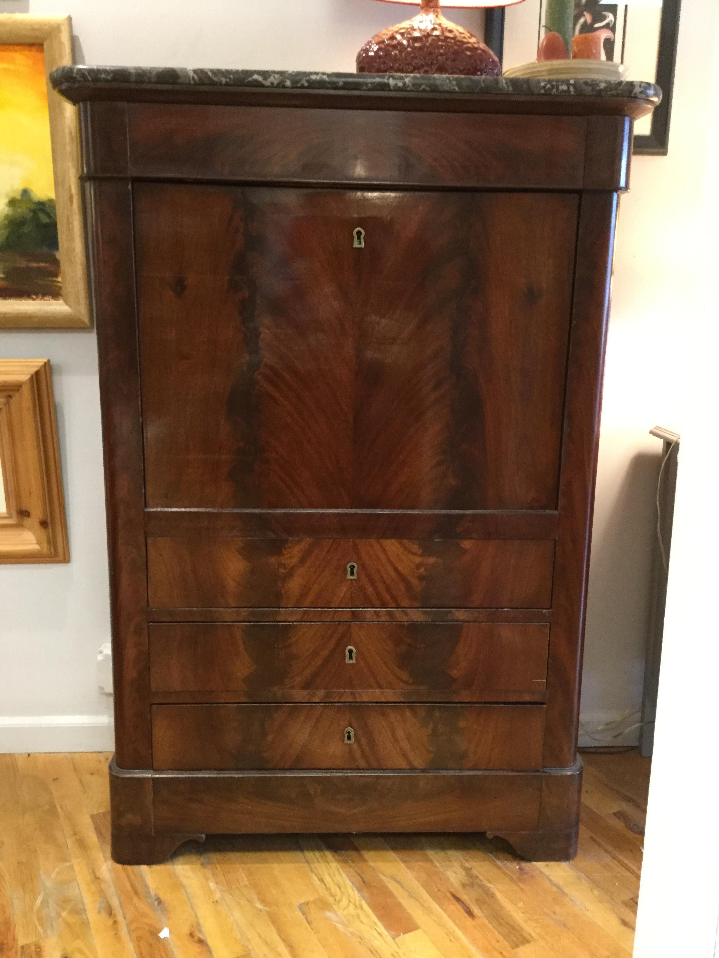 Handsome 19th century French flame mahogany secretary. With a gorgeous French-polished finish, this piece features three drawers and a drop-down writing area covered with dark green leather. Multiple cubby holes provide storage for papers and books.