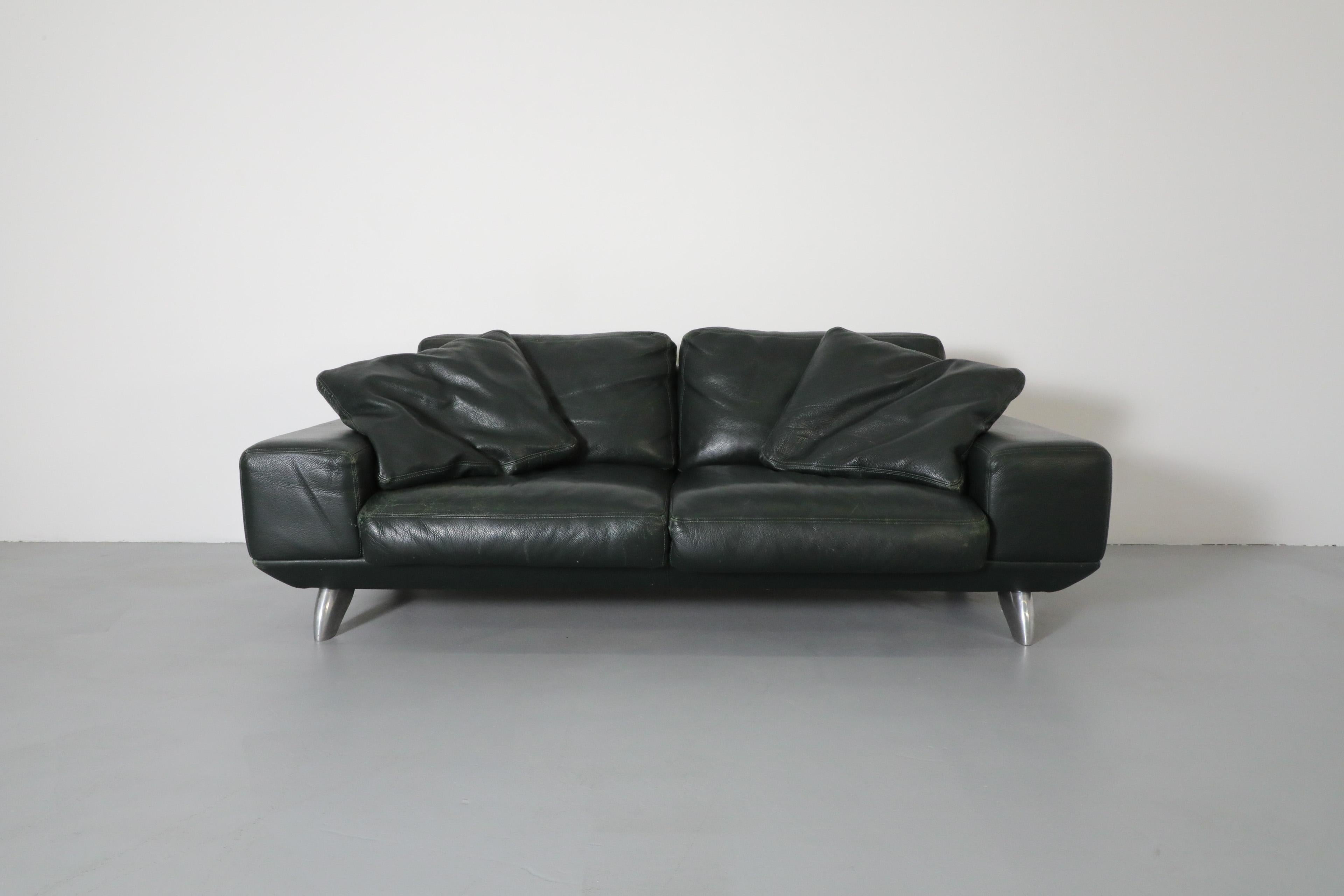 1980's MOD dark green leather sofa by Molinari. An attractive loungy loveseat with oversized armrests and molded chrome feet. This sofa is in original condition with some leather indentation and visible wear consistent with its age and regular use.