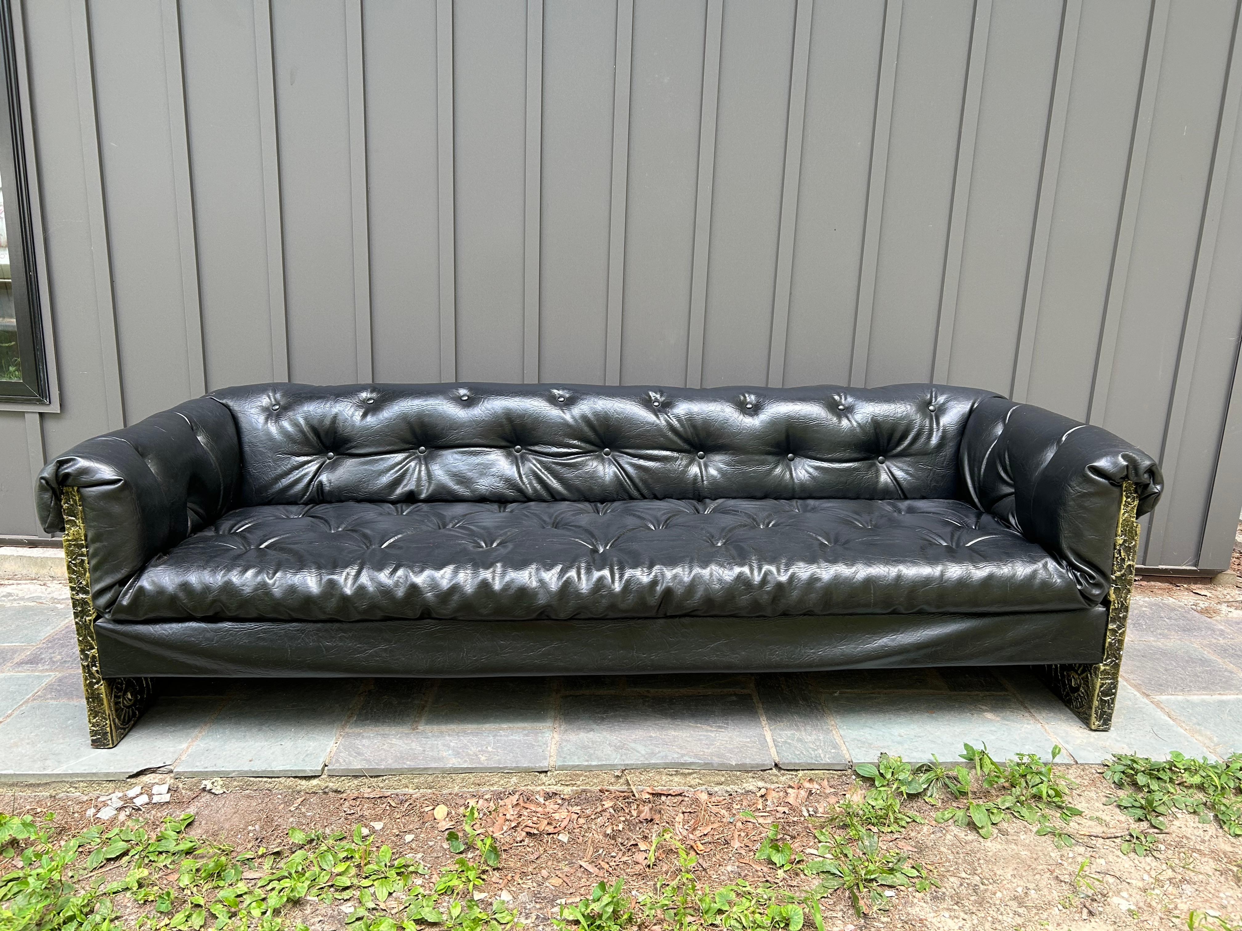 Handsome Adrian Pearsall all original Brutalist Goop designed sofa. Black vinyl leather tufted Chesterfield upholstery in amazing vintage condition. The sculpted sides have a brutalist black, gold and bronze finished Goop resin over wood. Appears to