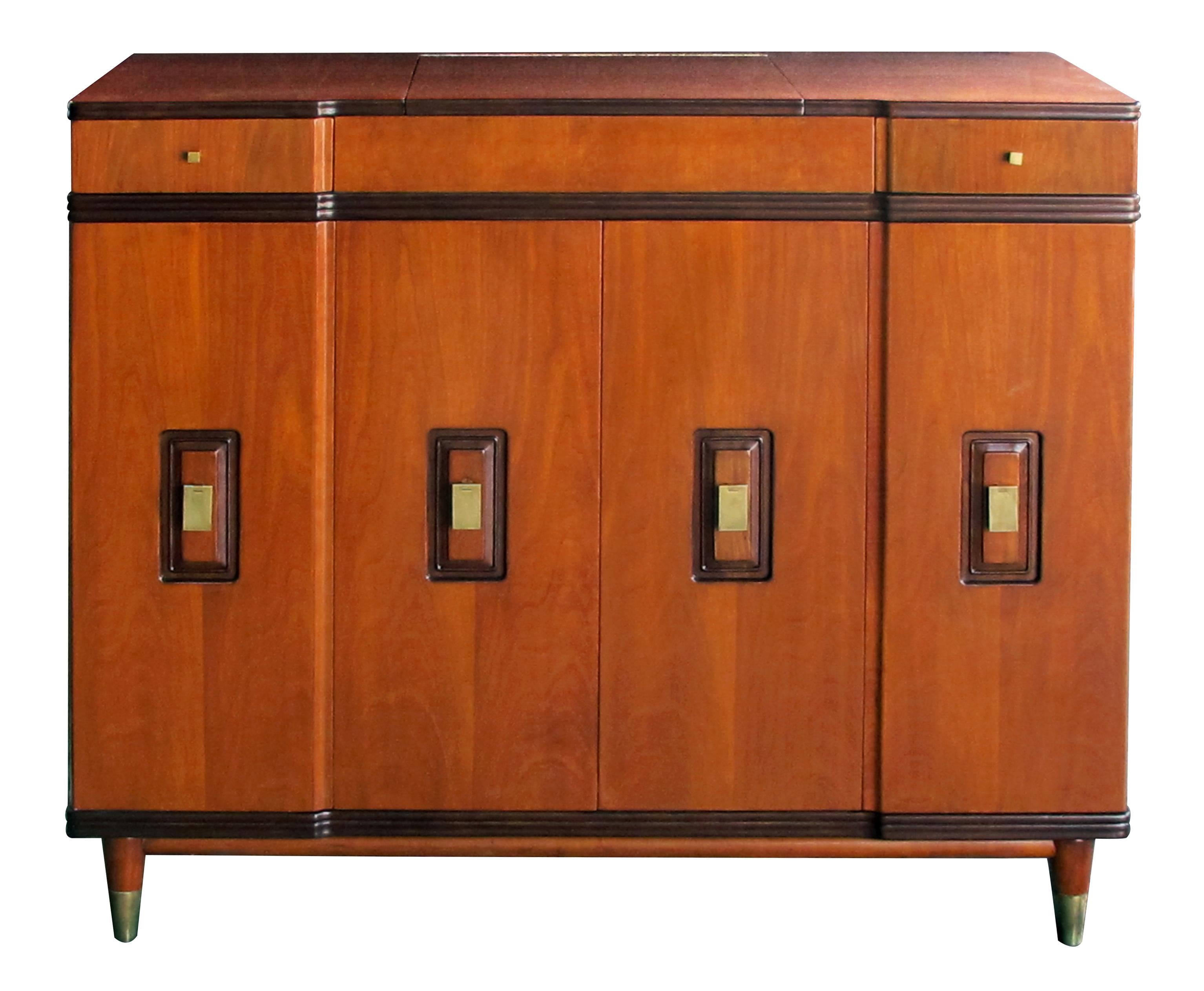 A handsome and rare American midcentury walnut dressing cabinet by John Widdicomb; how fantastic is this dressing cabinet/chest?; flip-up top with interior mirror and fitted compartment; above a shaped front with two bi-fold doors with interior