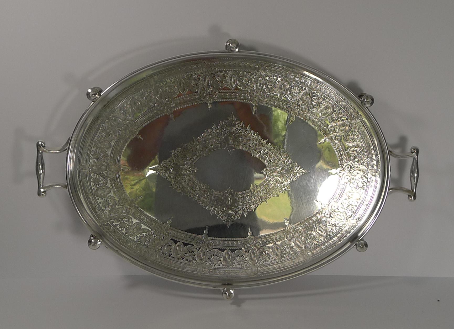 A hefty and very sold tray made from EPNS (Electro-Plated Nickel Silver) by the renowned silversmith, James Dixon and Sons, with full marks on the underside.

The base of this galleried tray is beautifully engraved, highly decorative.

Dating to