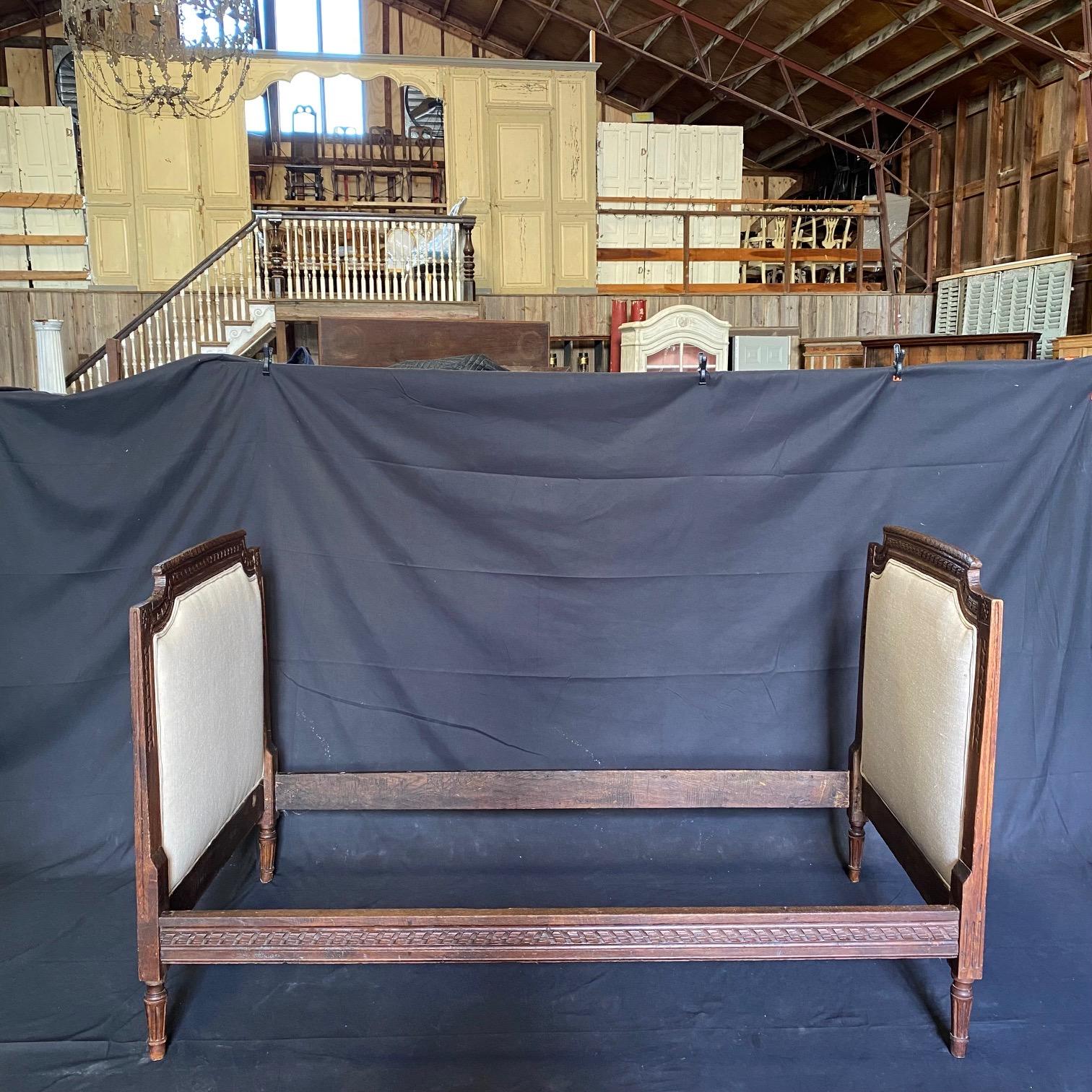 18th century Elizabethan oak carved bed. Early and intricately carved legs and stretchers. Wonderful age and patina updated with new upholstery. Does not come with mattress; needs custom mattress. #4031

 H rails 13” W inside 69.5” D inside
