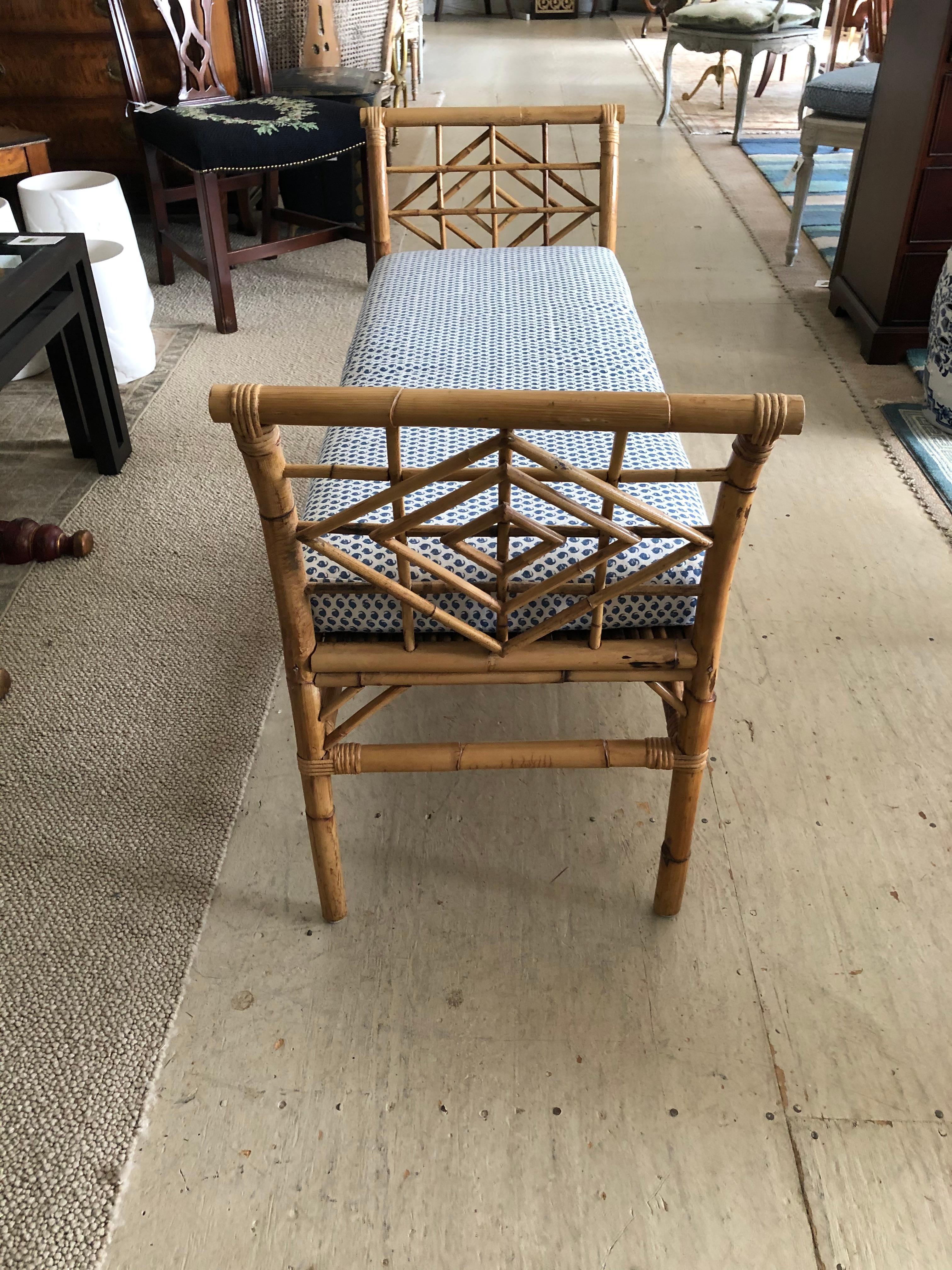 Handsome vintage bamboo bench having stunning lattice style handiwork on each side and substantial well made seat with custom upholstered blue and white seat cushion.