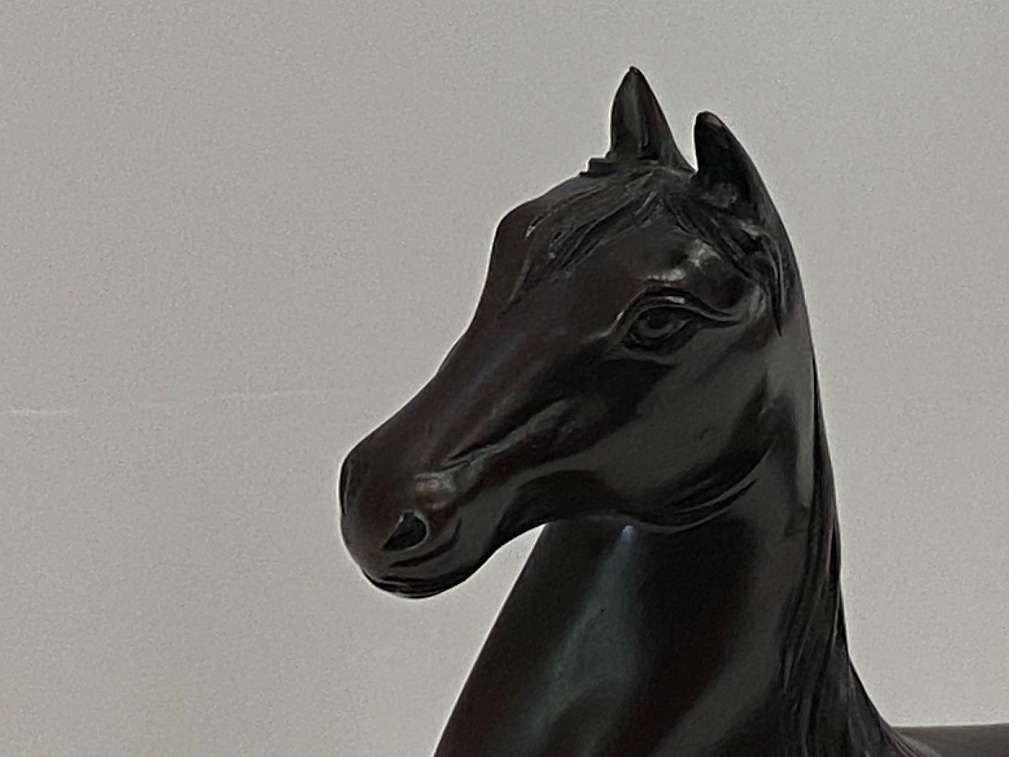 Striking sculpture of a cast bronze horse with beautiful details mounted on a wood base.