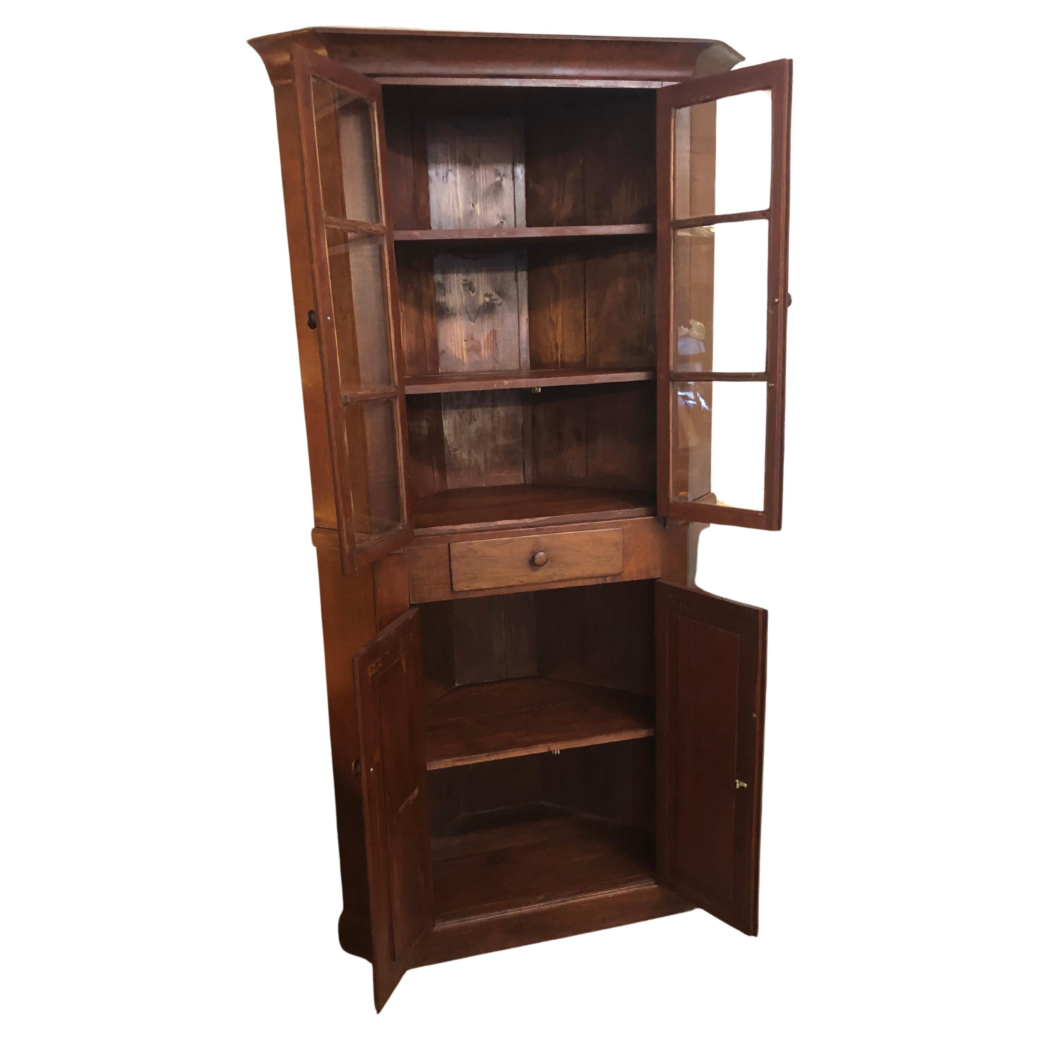 Handsome functional vintage cherry corner cupboard custom made in Middlesbury VA having old glass in top doors with two fixed interior shelves; Top shelves have 11