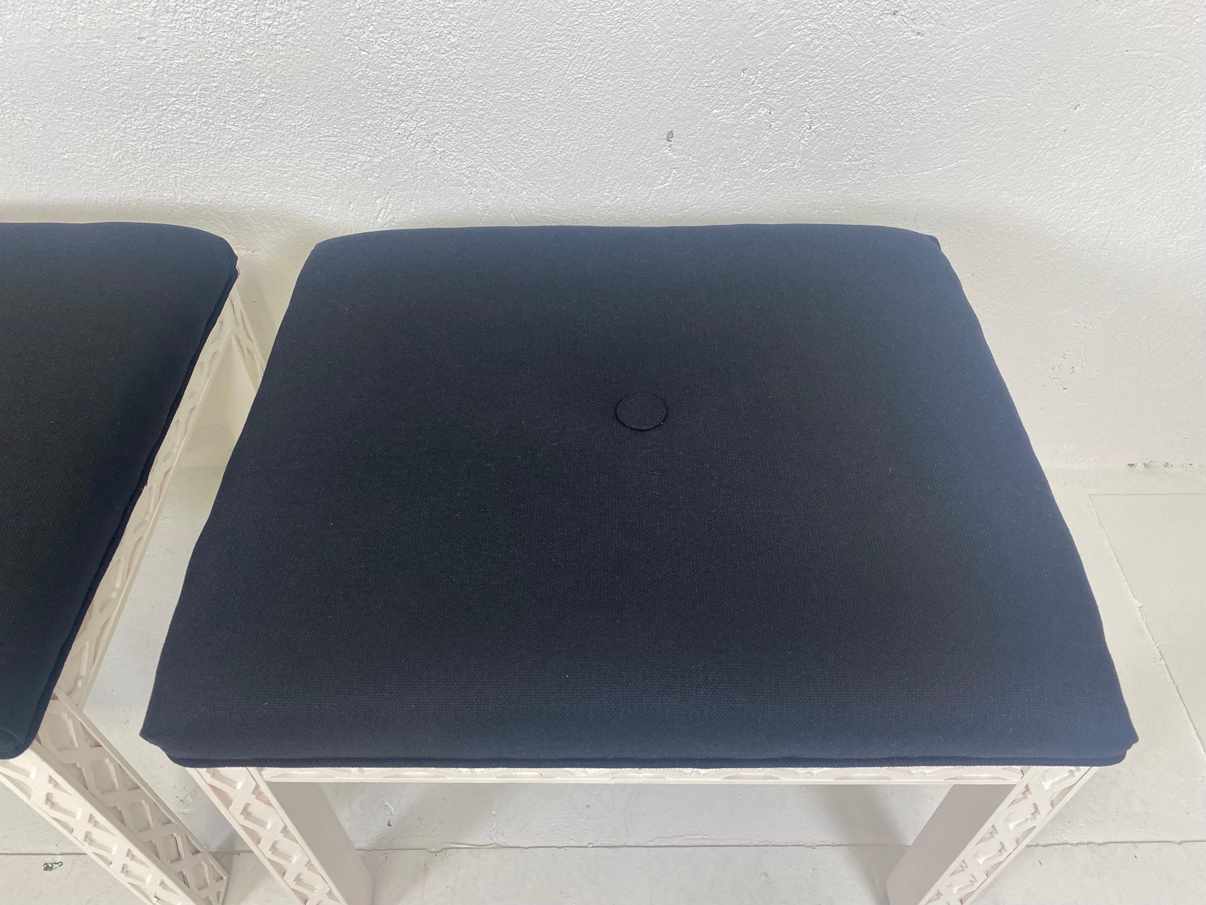 This is a pair of mid century Vintage Chippendale style benches. The Chippendale style legs on these benches have been painted white and have a black cotton upholstery with a large button in the center. These benches are American made circa 1970.