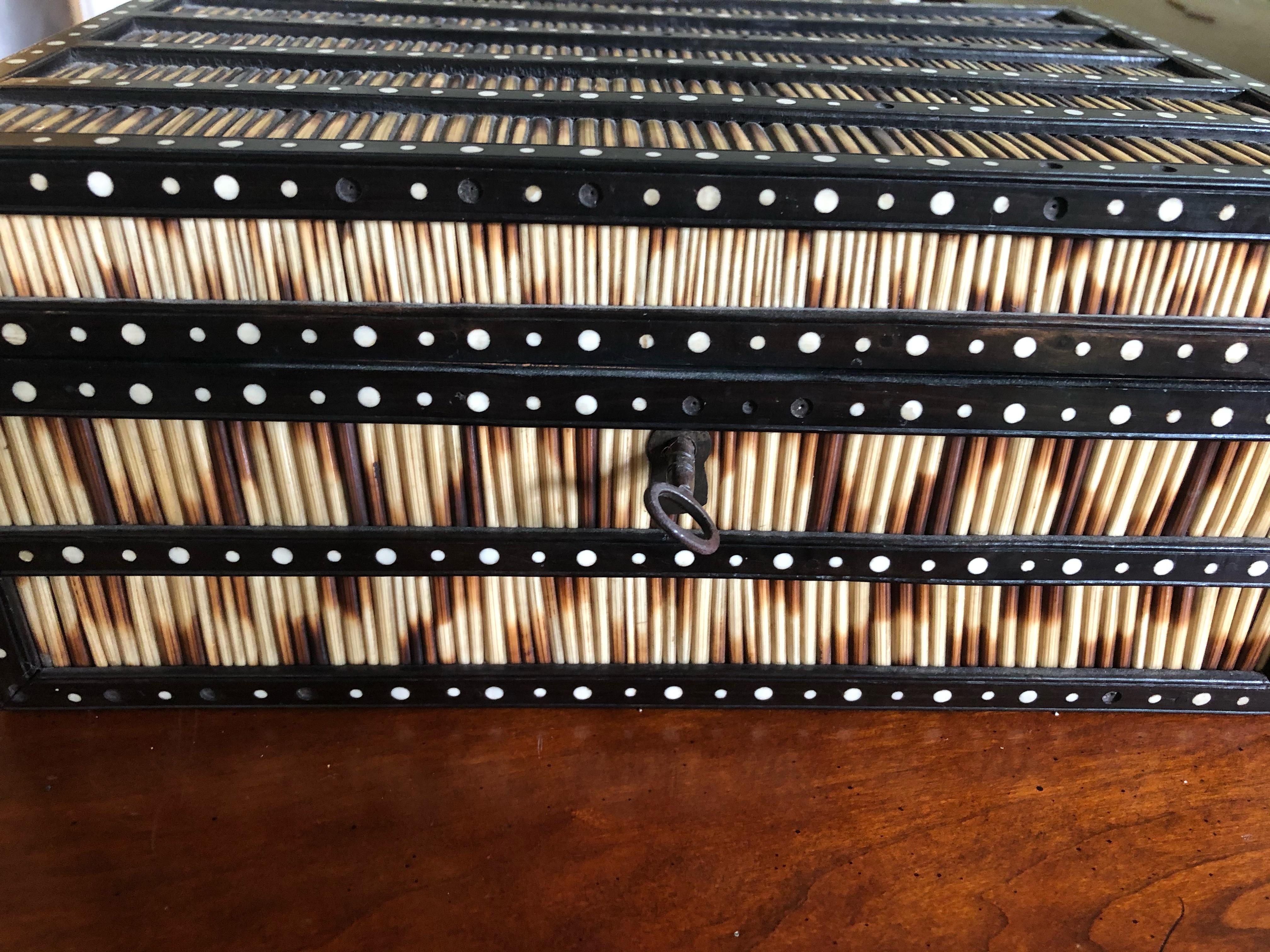 Striking Anglo Indian box with porcupine quills framed by ebonized rosewood with circular bone inlay. Functional lock with skeleton key. Has interior removable tray with 9 small compartments. All quills are intact. Some loose bone inlays which is