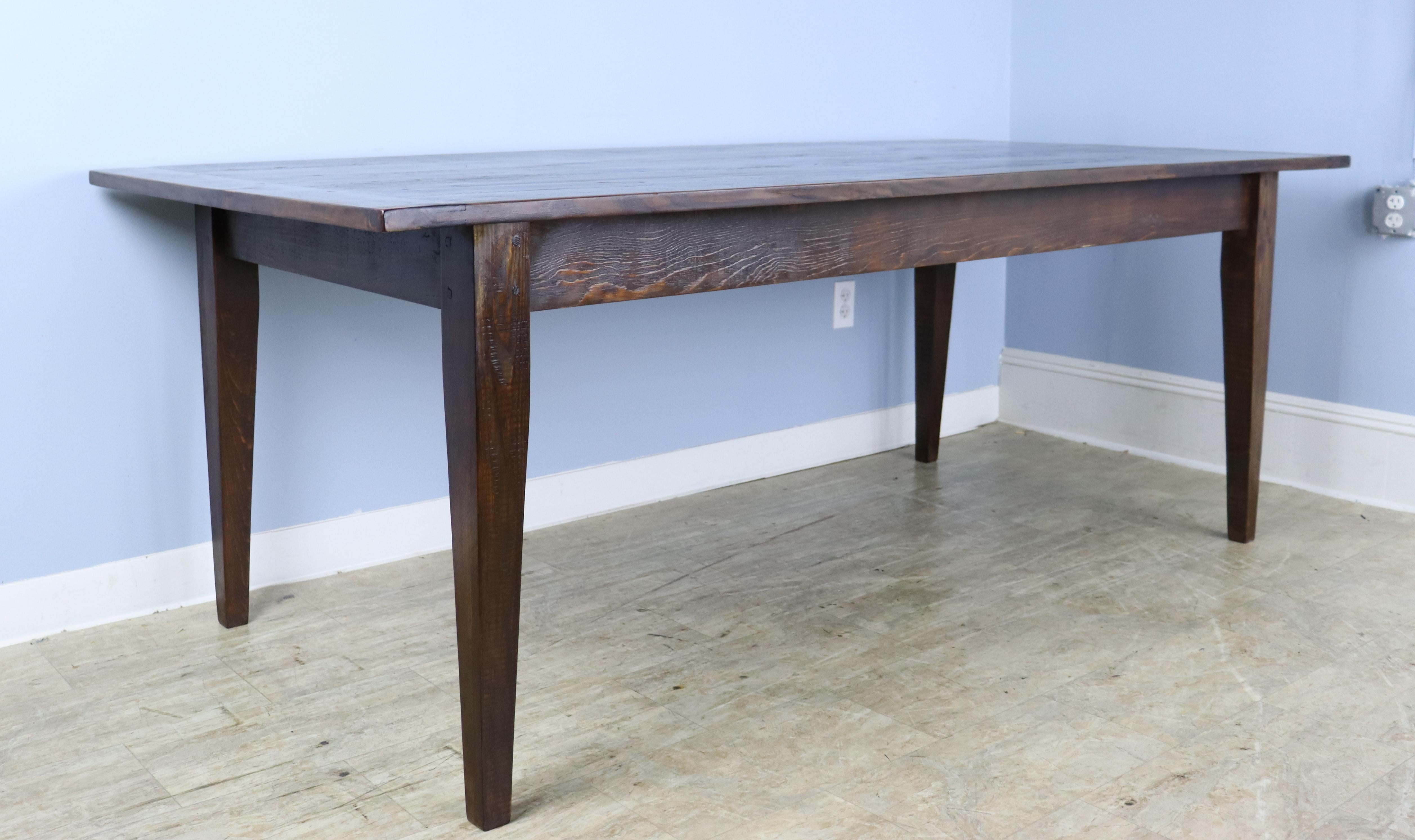 A generously proportioned, thick topped pine farm table stained in a rich brown, 7' with some mild faux distress. With 68 inches between the legs, this table can easily fit eight with room for a Thanksgiving dinner as well! The apron height of 25