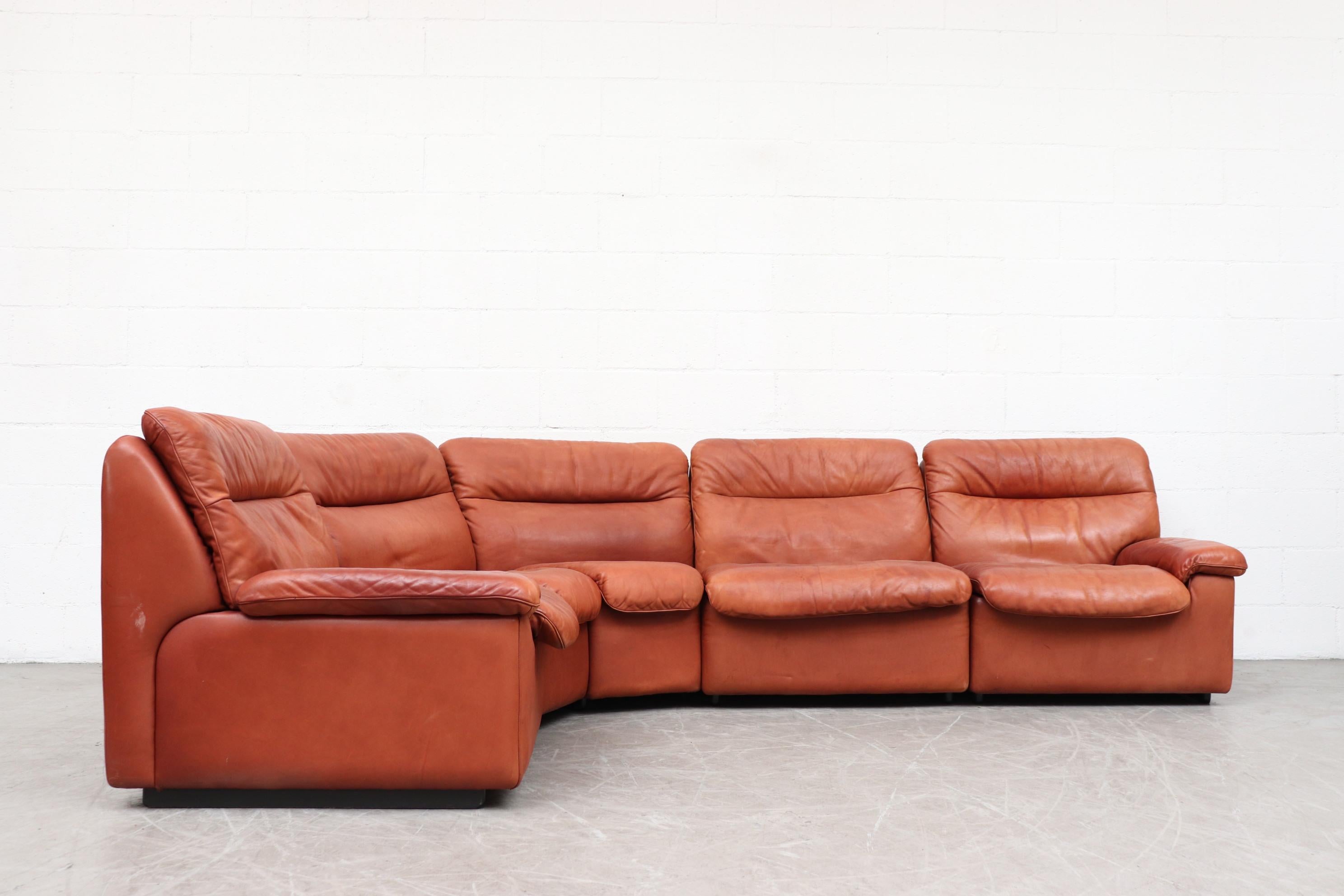 Handsome De Sede 5-piece cognac leather sectional sofa. Beautiful patina, thick leather. In original condition with visible wear. Minimal stains and two small tears on a cushion back as well as a very worn back corner spot (pictured). All signs of