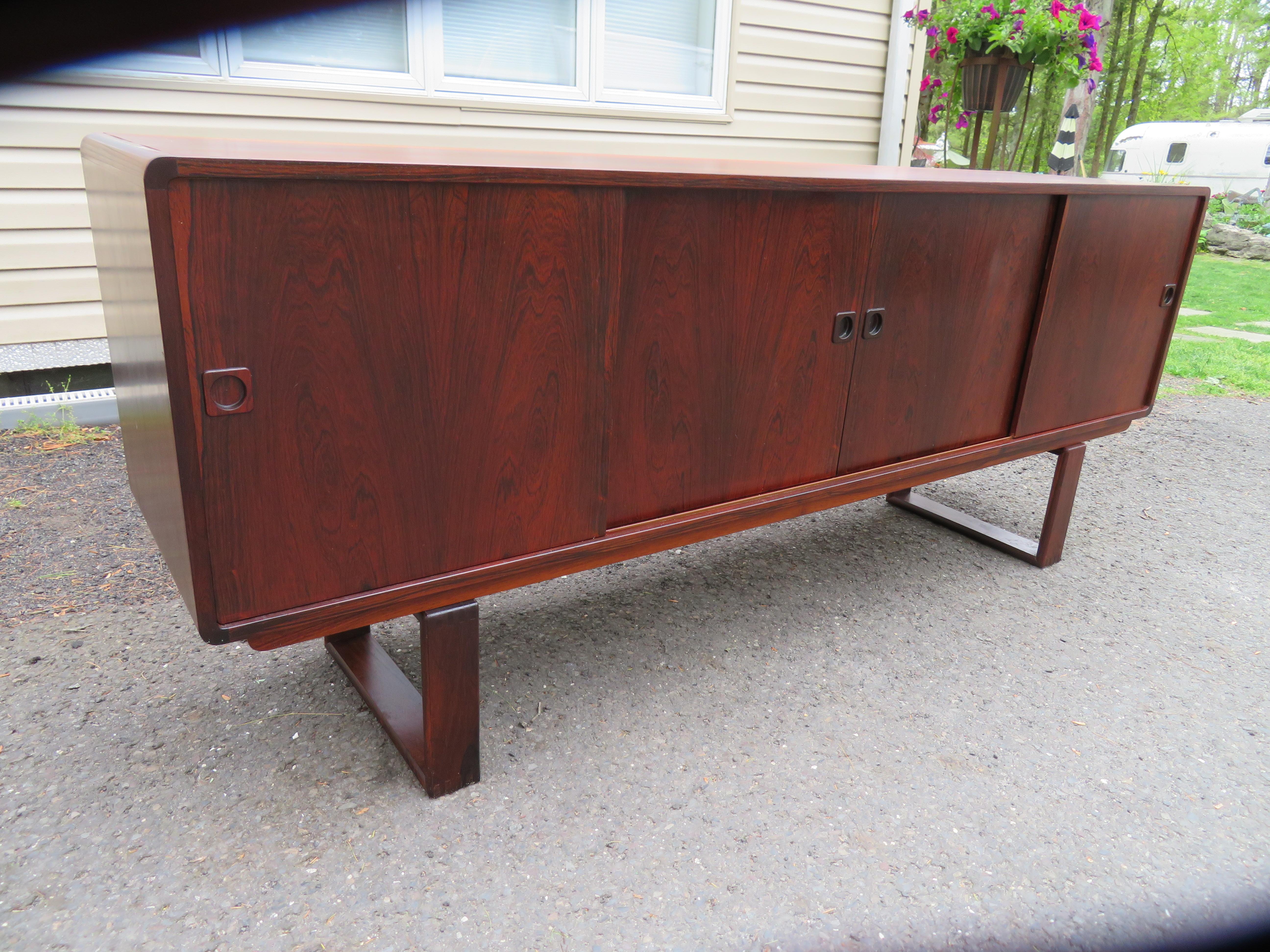 Handsome Dyrlund Danish Modern rosewood credenza with unusual sled legs. The rosewood has a rich deep and dark finish. This piece measures 32