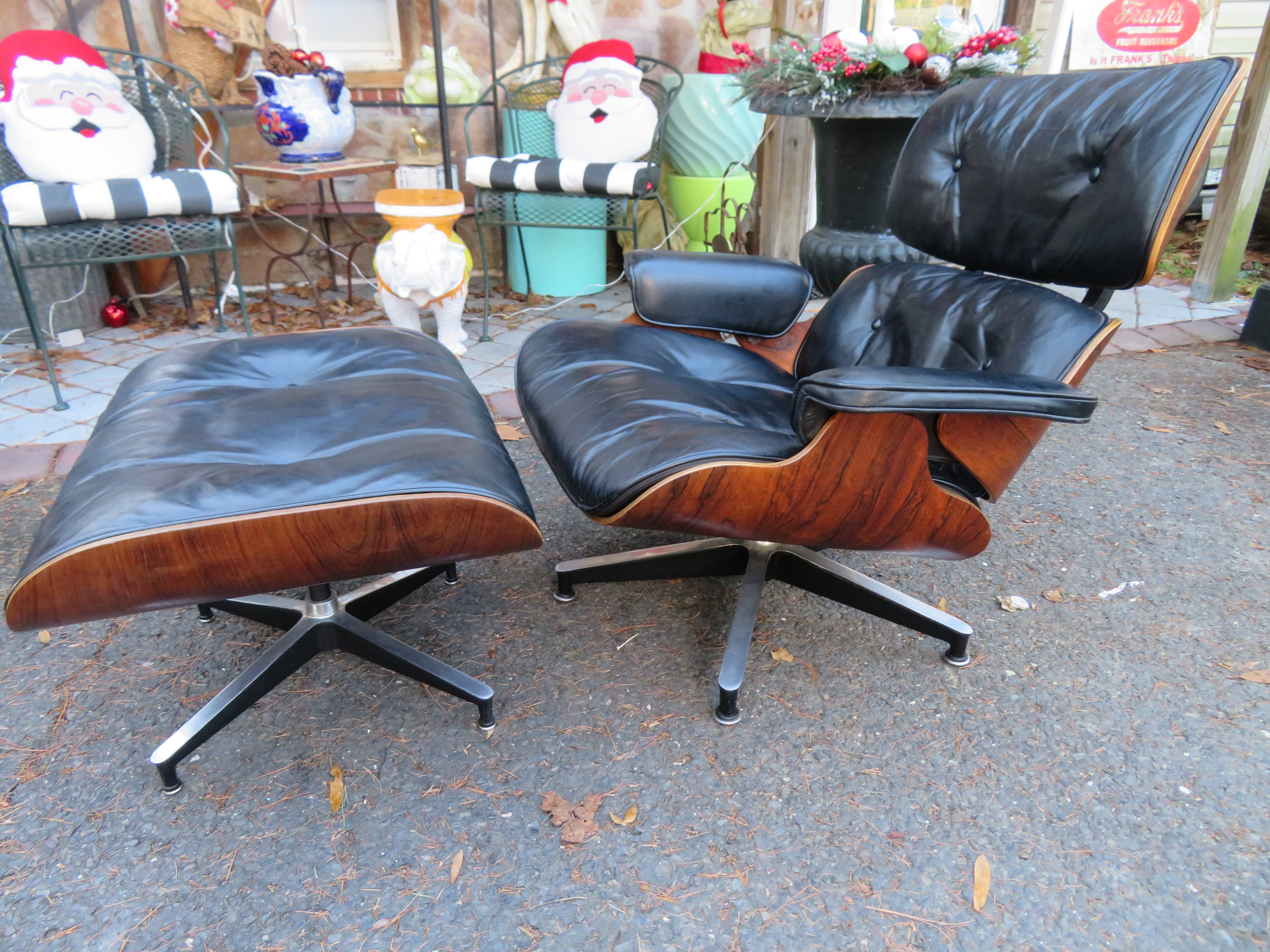 Handsome second-generation Charles and Ray Eames lounge chair with ottoman by Herman Miller. Early 1960s production. The rosewood has a beautiful wood grain and rich color with some light wear and is in very good condition. The black leather has a
