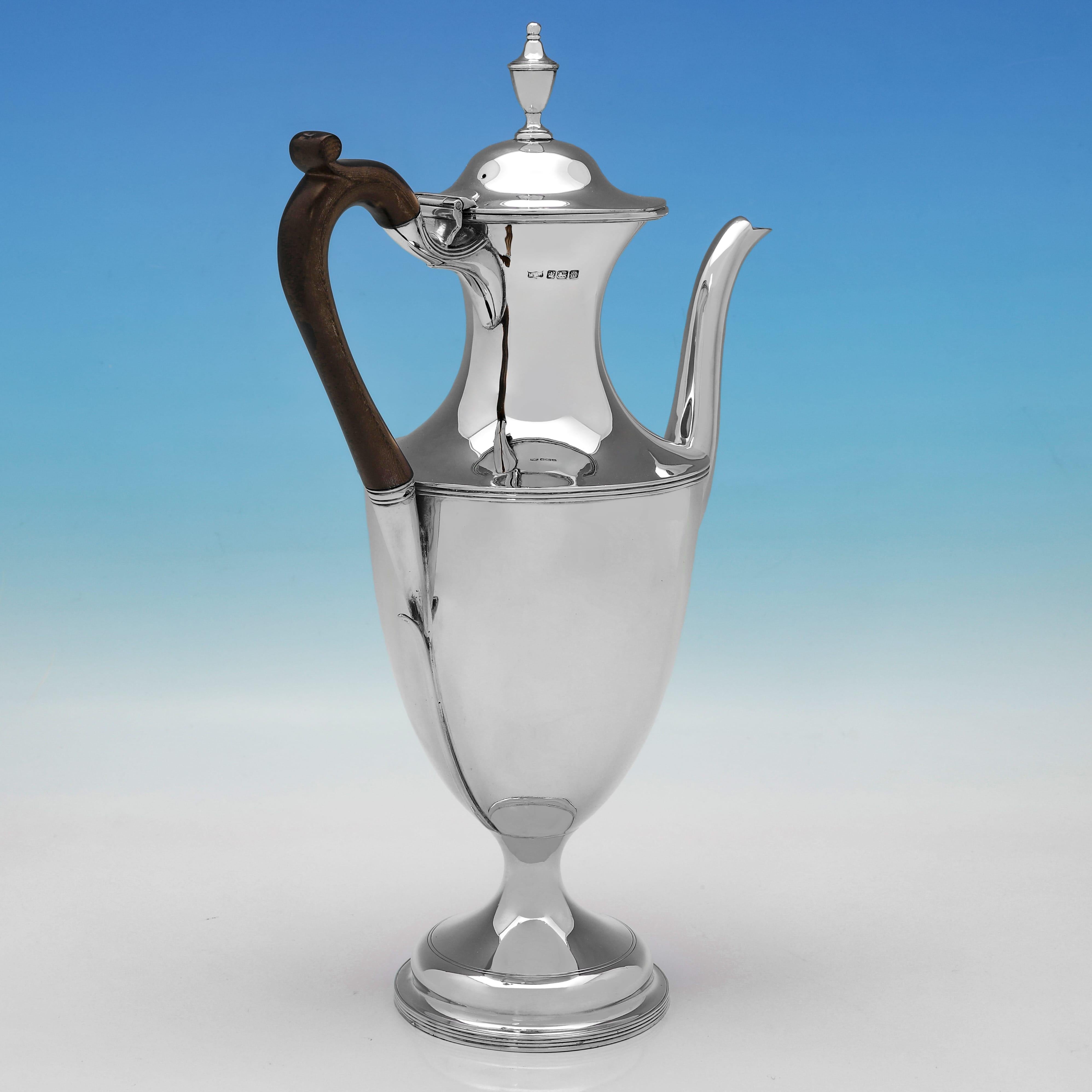 Marcada en Sheffield en 1904 por Mappin & Webb, esta bonita cafetera de plata de ley antigua tiene forma de urna, es de estilo sencillo y presenta un asa de madera y bordes de junco alrededor del pie del pedestal. La cafetera mide 35 cm de alto por