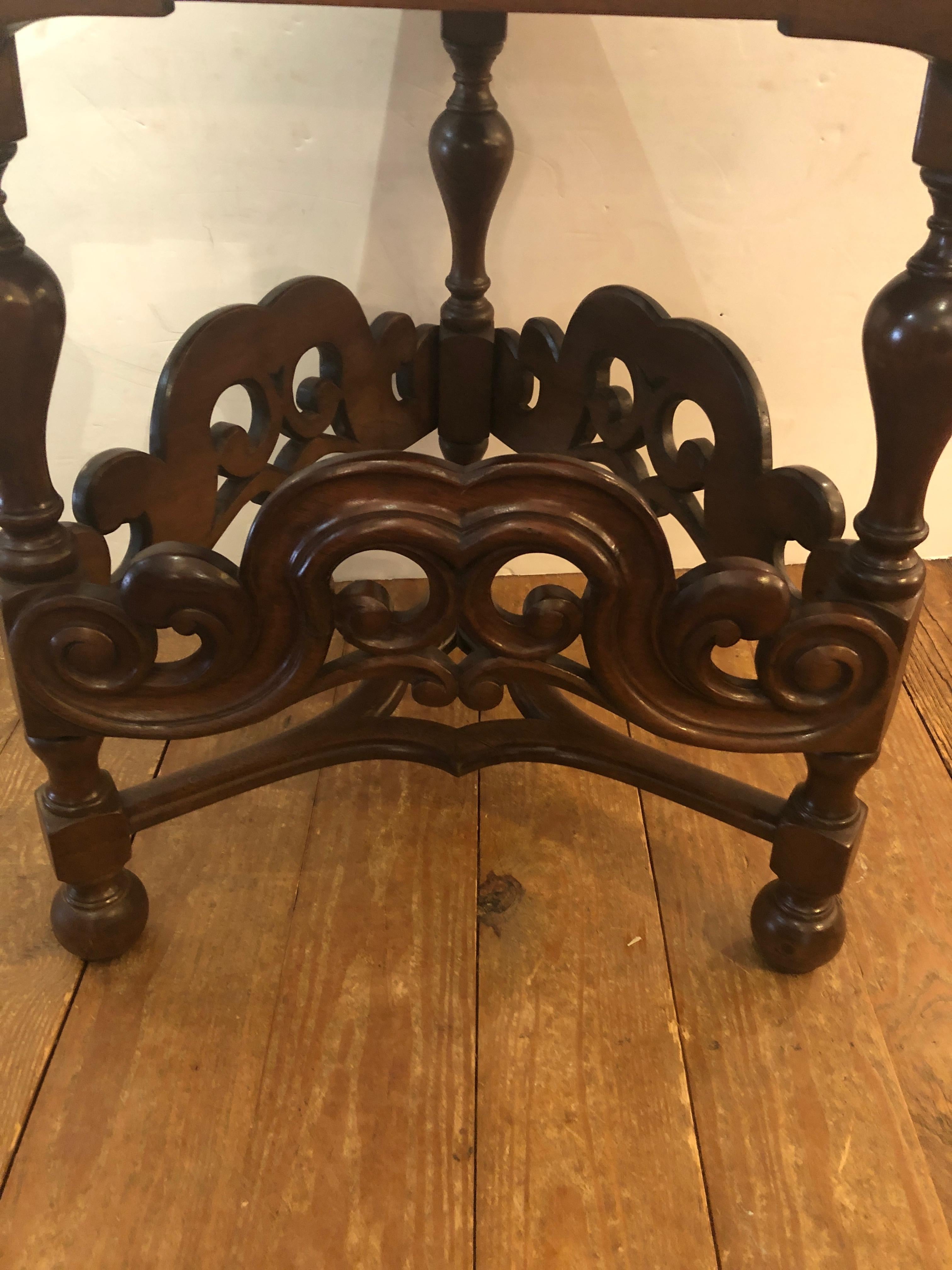 Antique English walnut end table in a wonderful triangular shape with gorgeous grain having fancy turned legs and curlicue stretchers.