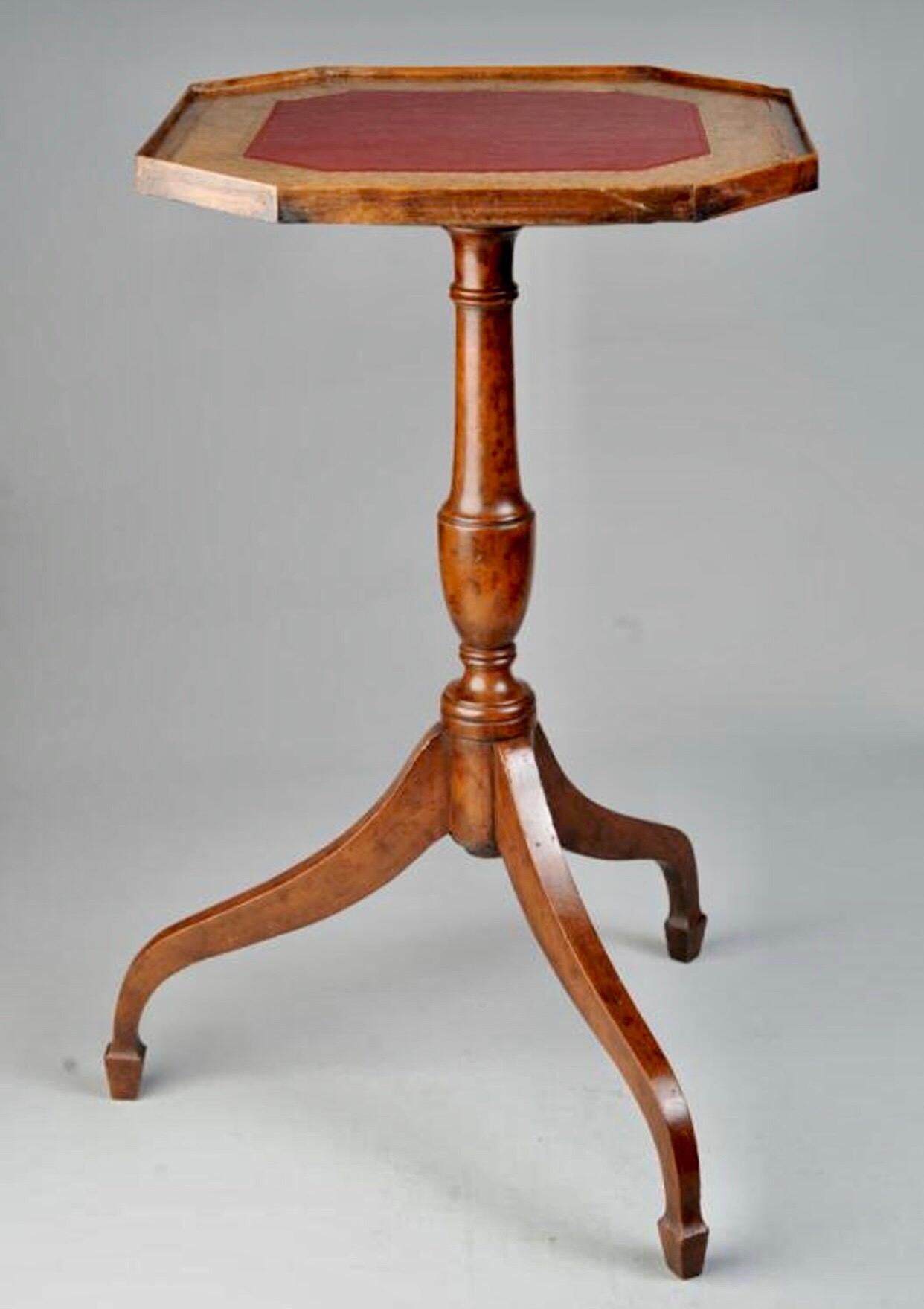 A handsome and always useful Federal style tilt-top table having octagonal leather inset top resting on a hand-turned pedestal with spider legs that terminate on high spade feet. A Classic and timeless drinks table.