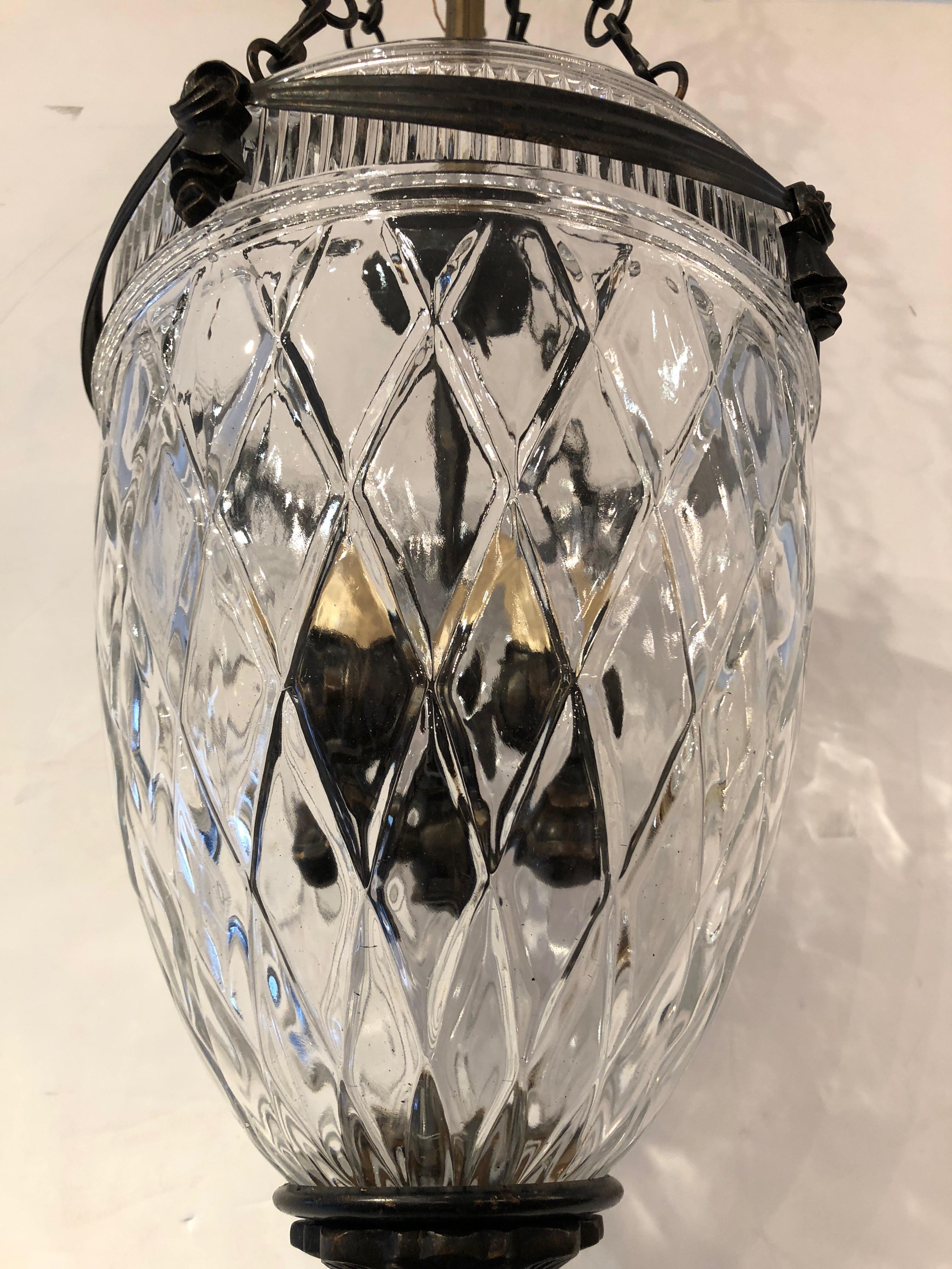 Beautiful lantern pendant having heavy pressed glass dome adorned with bronze colored brass swags and pine cone finial. Great for a hallway or small foyer.